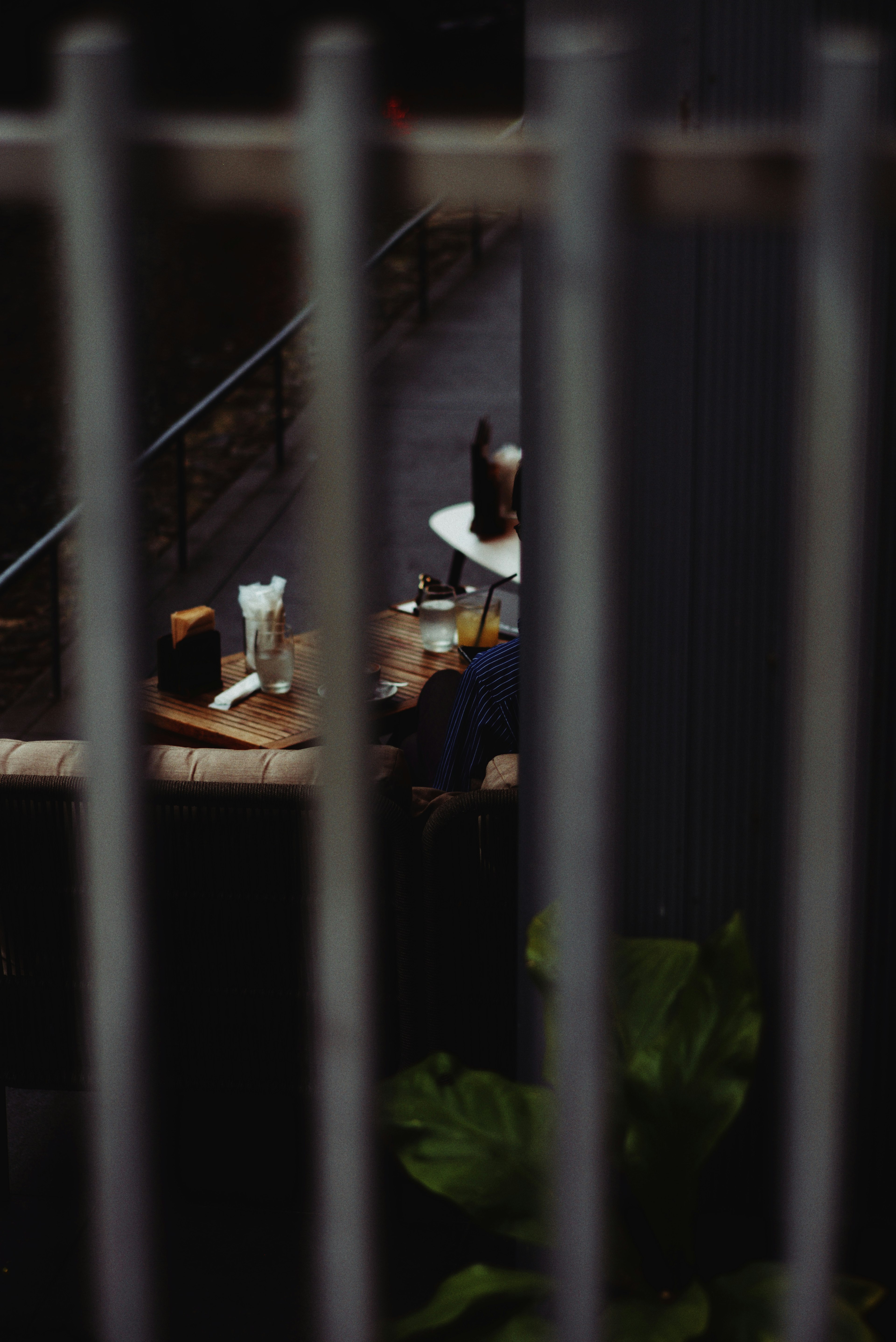 Cafe table with drinks seen through a fence