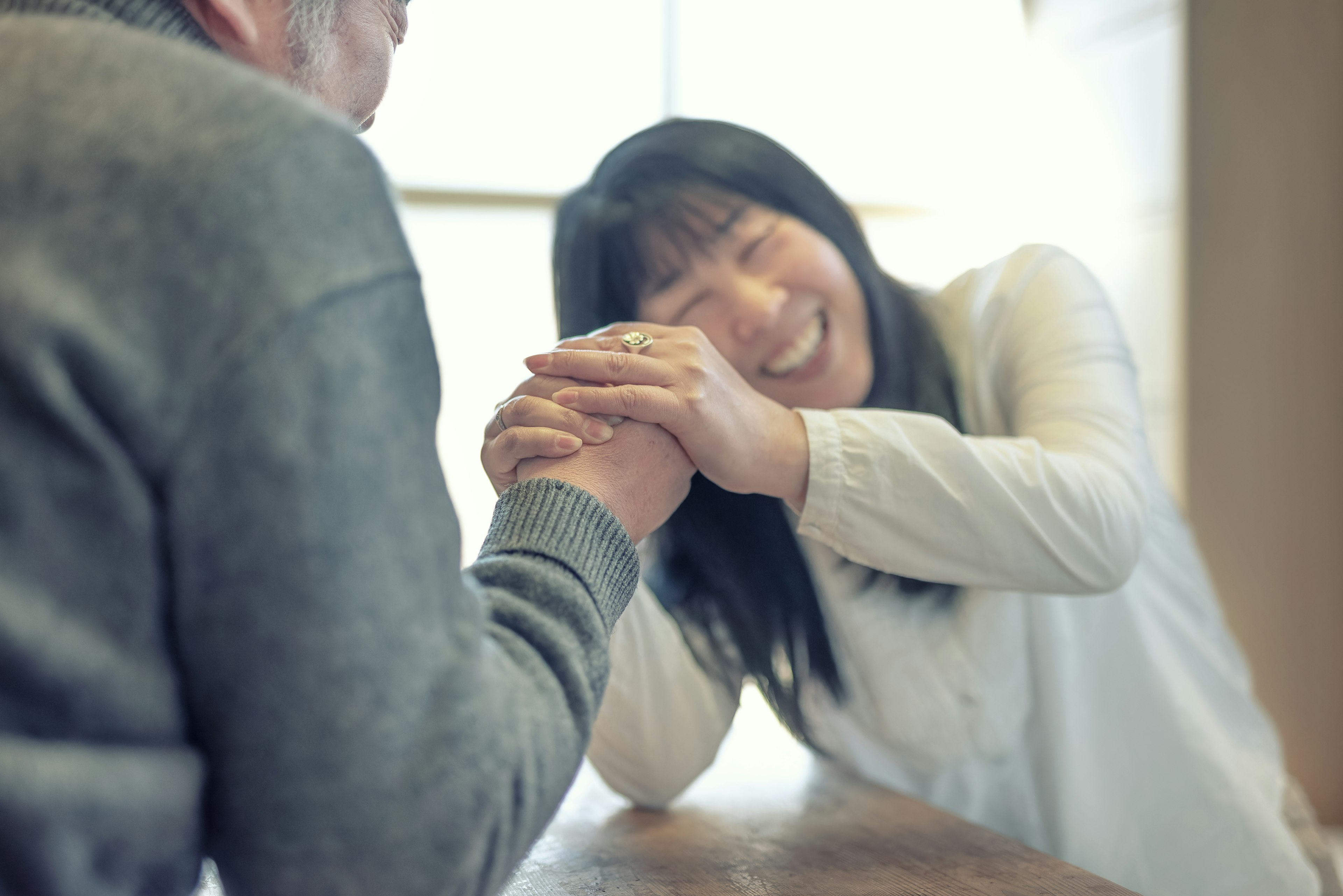 一位女性与一名男性快乐地进行臂力比赛