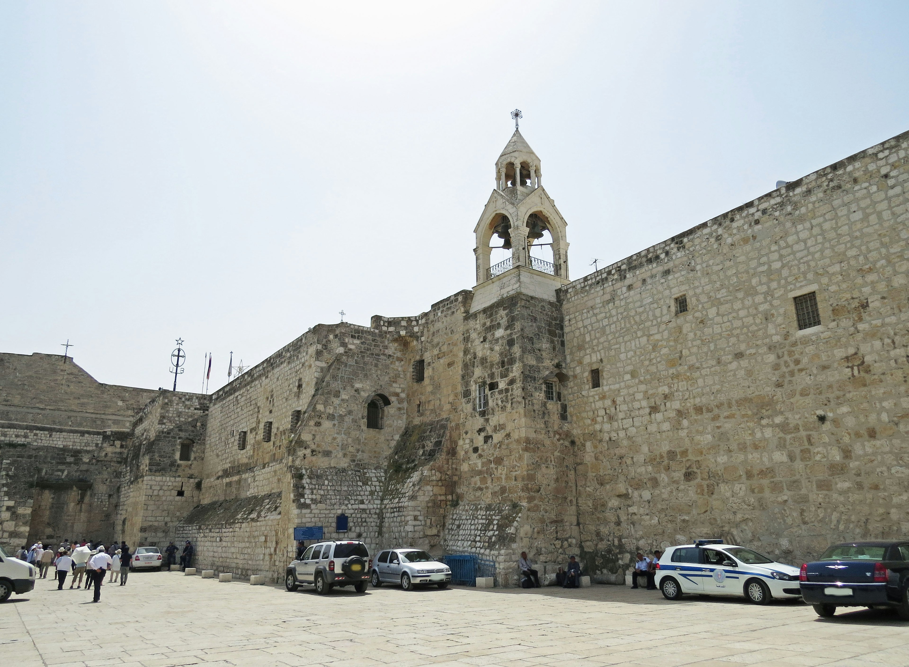 Exterior view of a historic building with stone walls and a bell tower