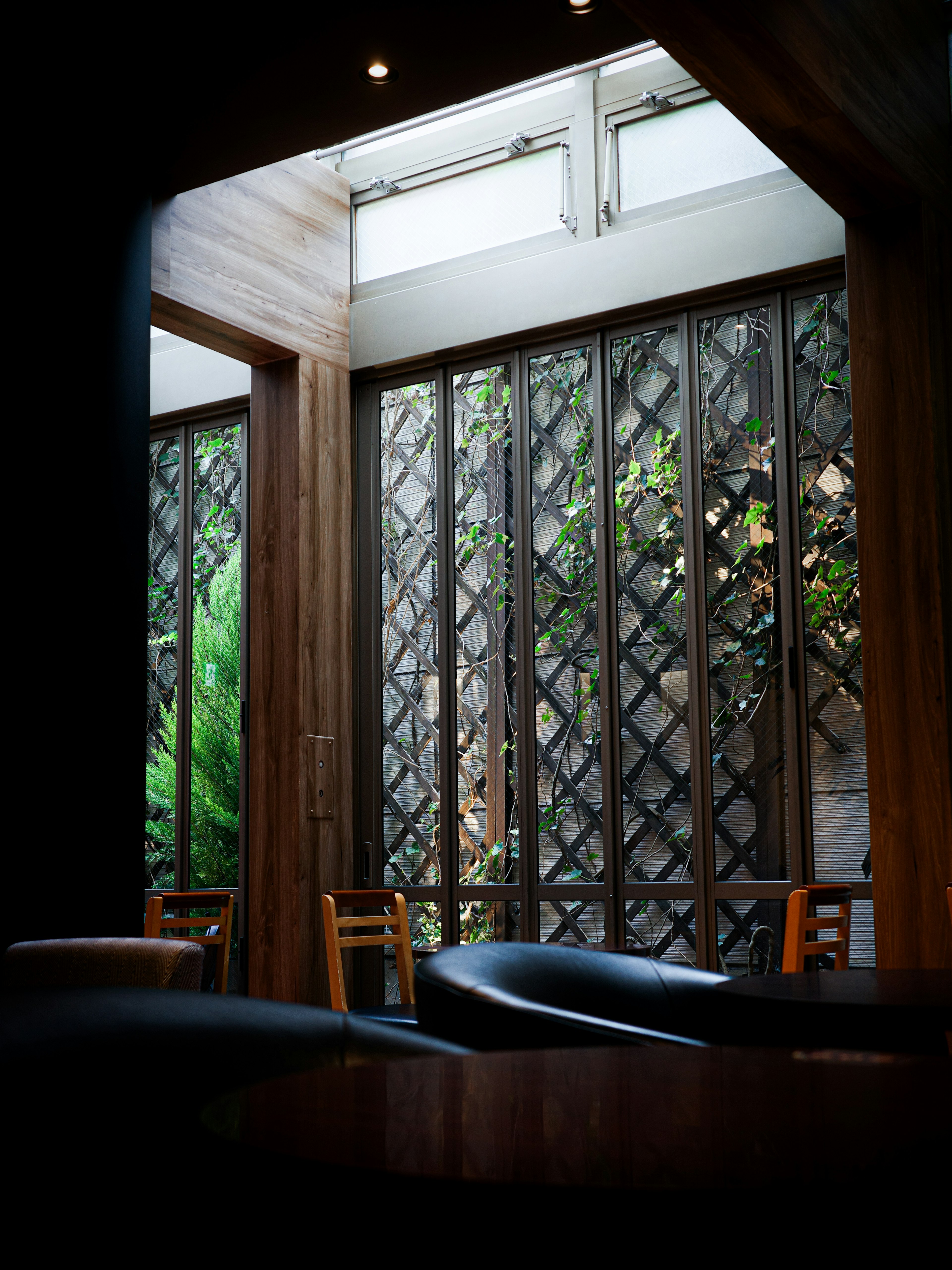 Innenansicht eines ruhigen Cafés mit Holzwänden und natürlichem Licht durch die Fenster