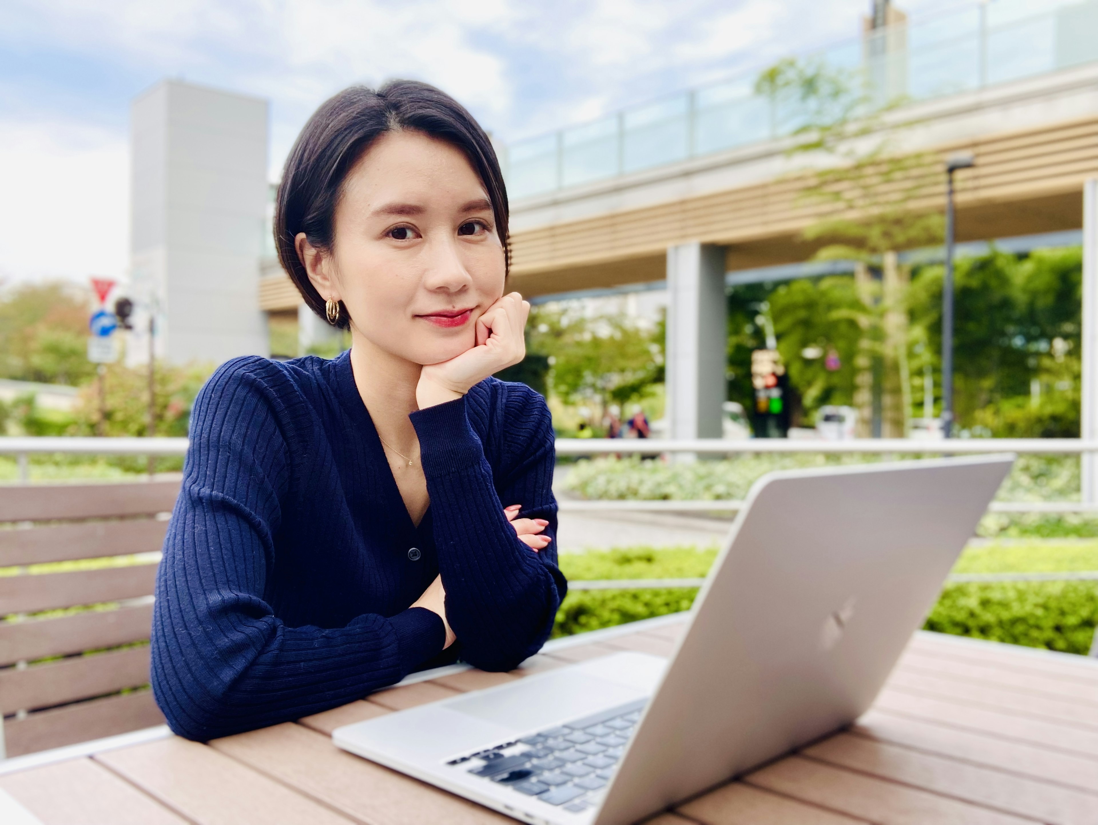 在公園裡使用筆記型電腦思考的女性