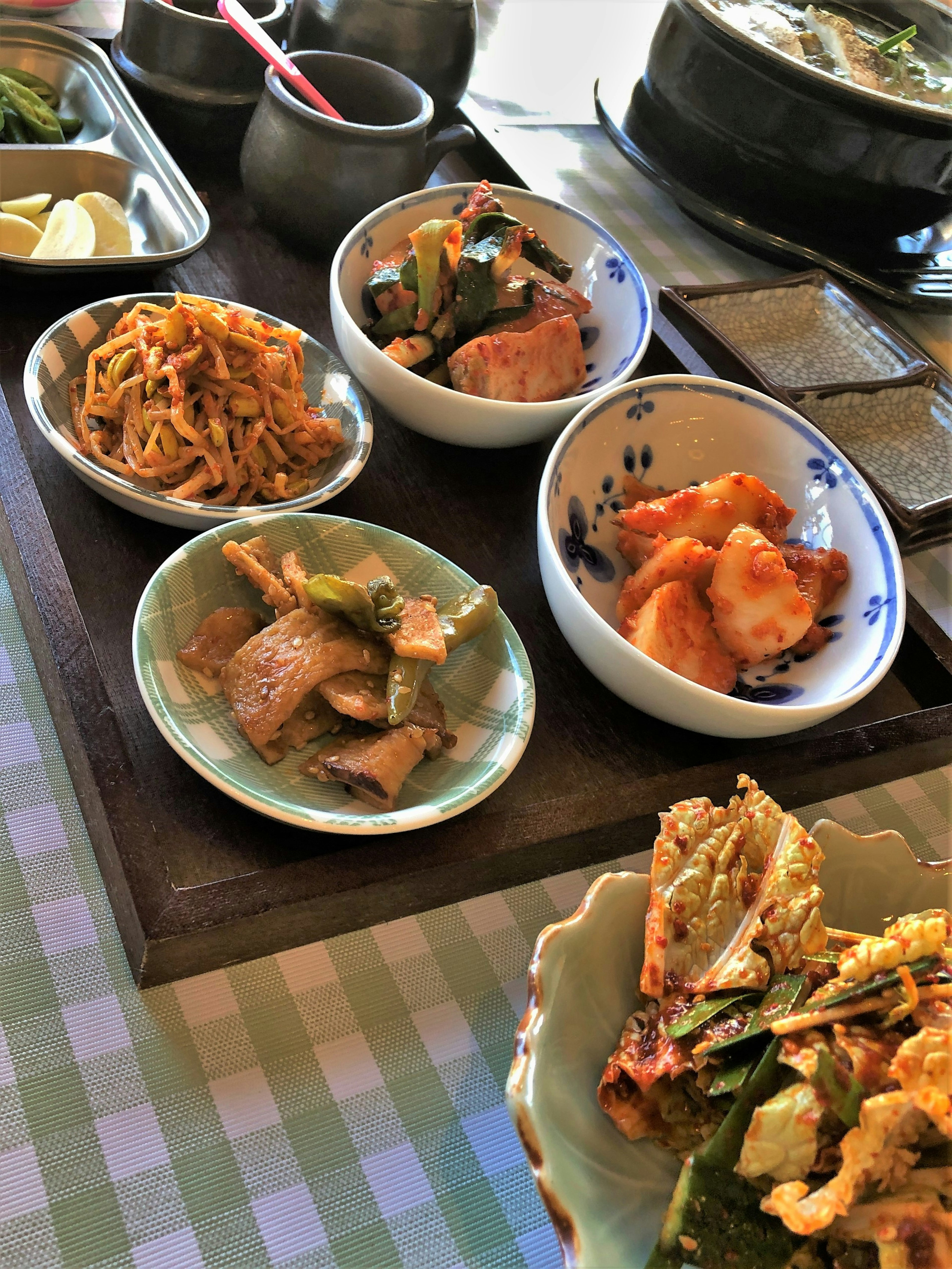 Una mesa con una variedad de platos coreanos servidos en pequeños cuencos