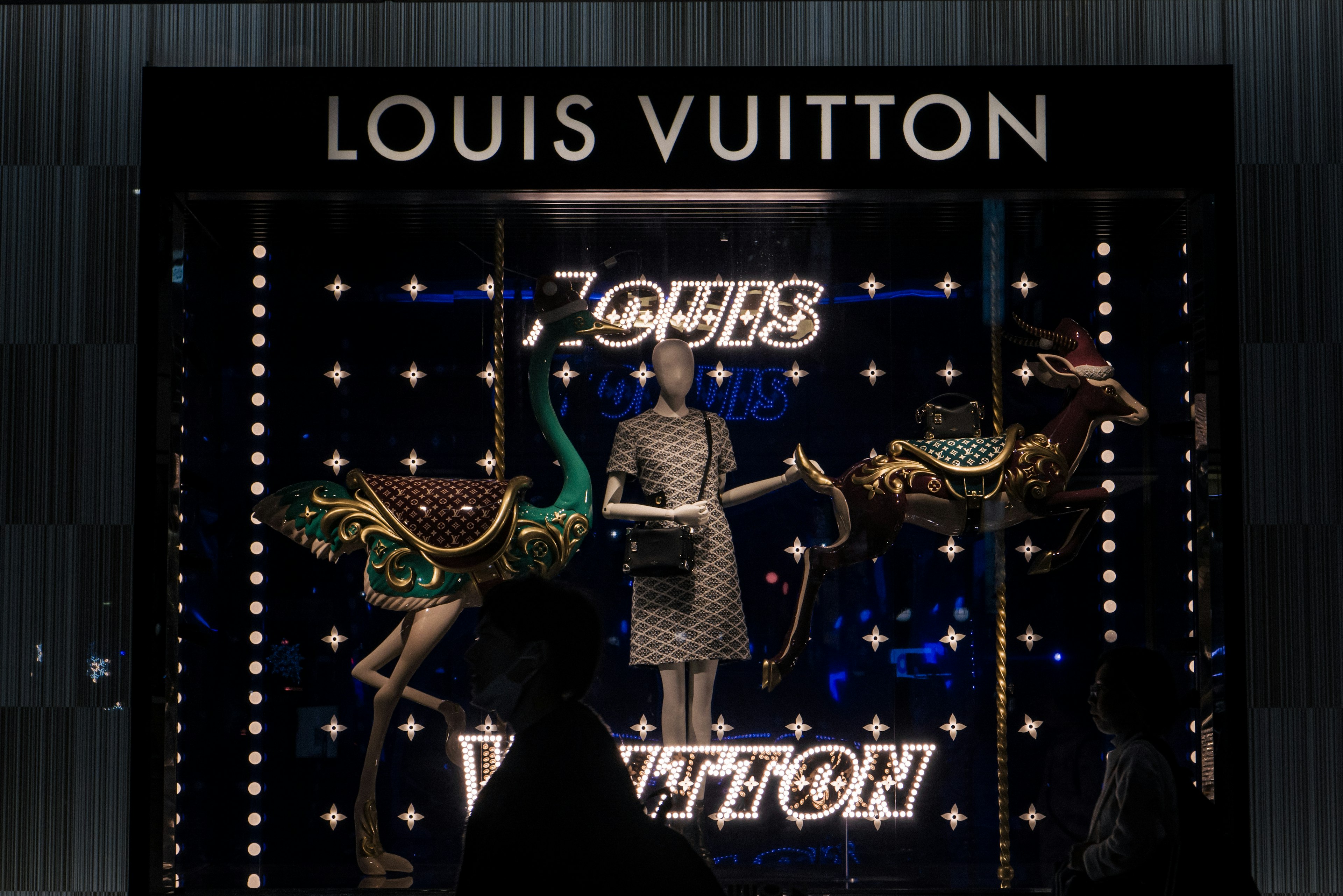 หน้าต่างแสดงสินค้าของ Louis Vuitton ที่มีหุ่นและกระเป๋าประดับ