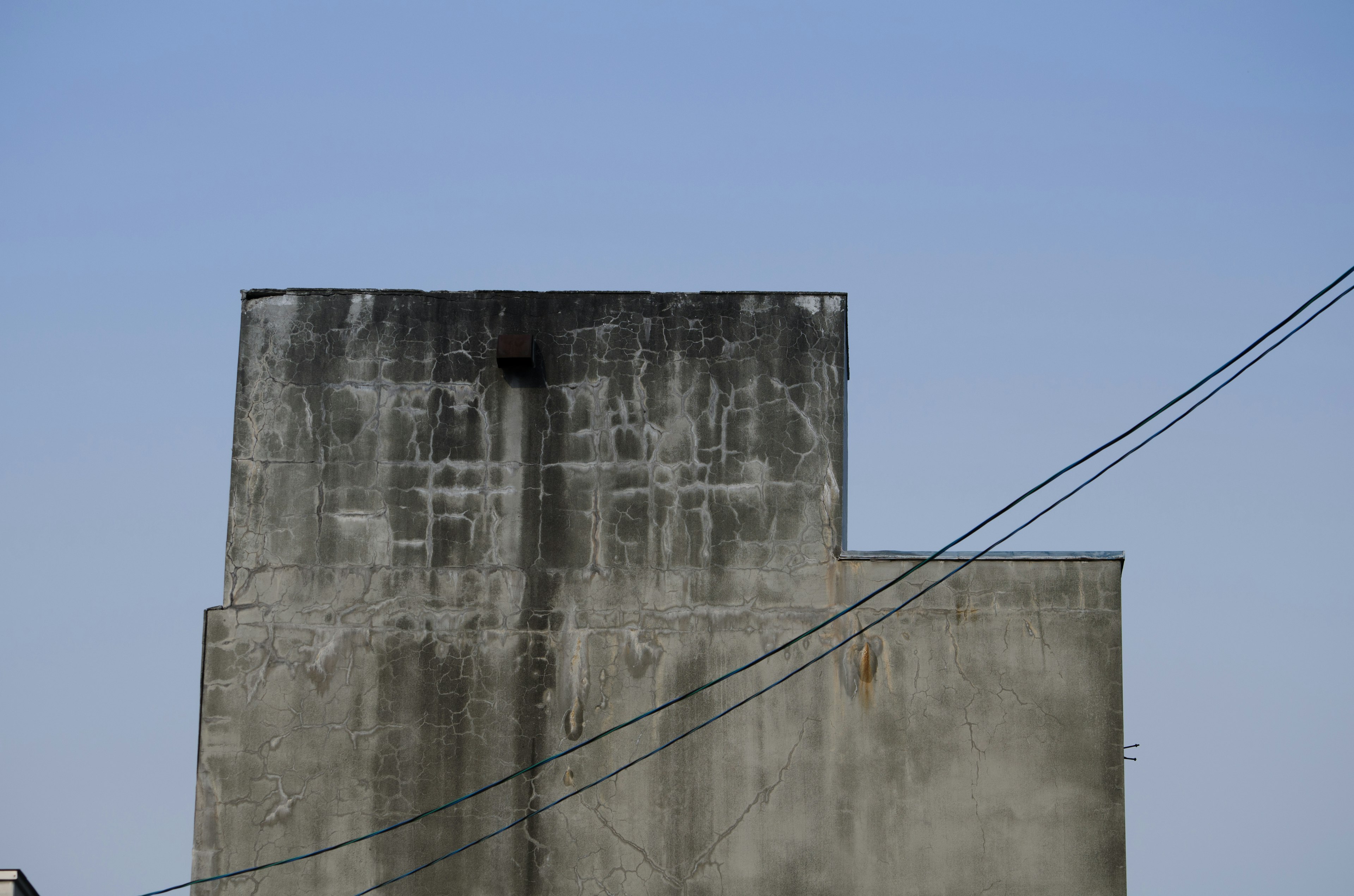 Part of an old concrete building under a blue sky