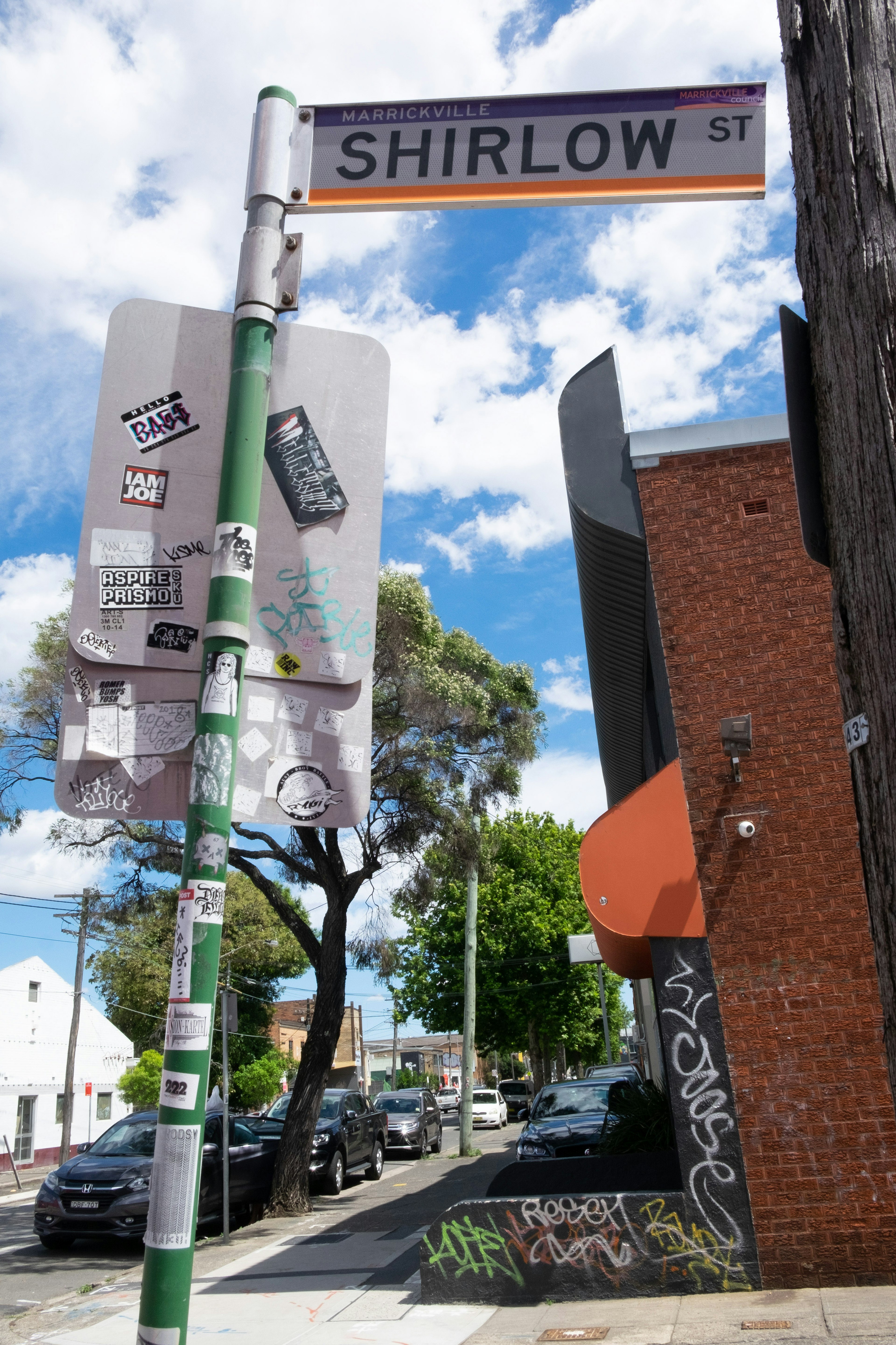 Shirlow Street sign with surrounding buildings and blue sky with clouds