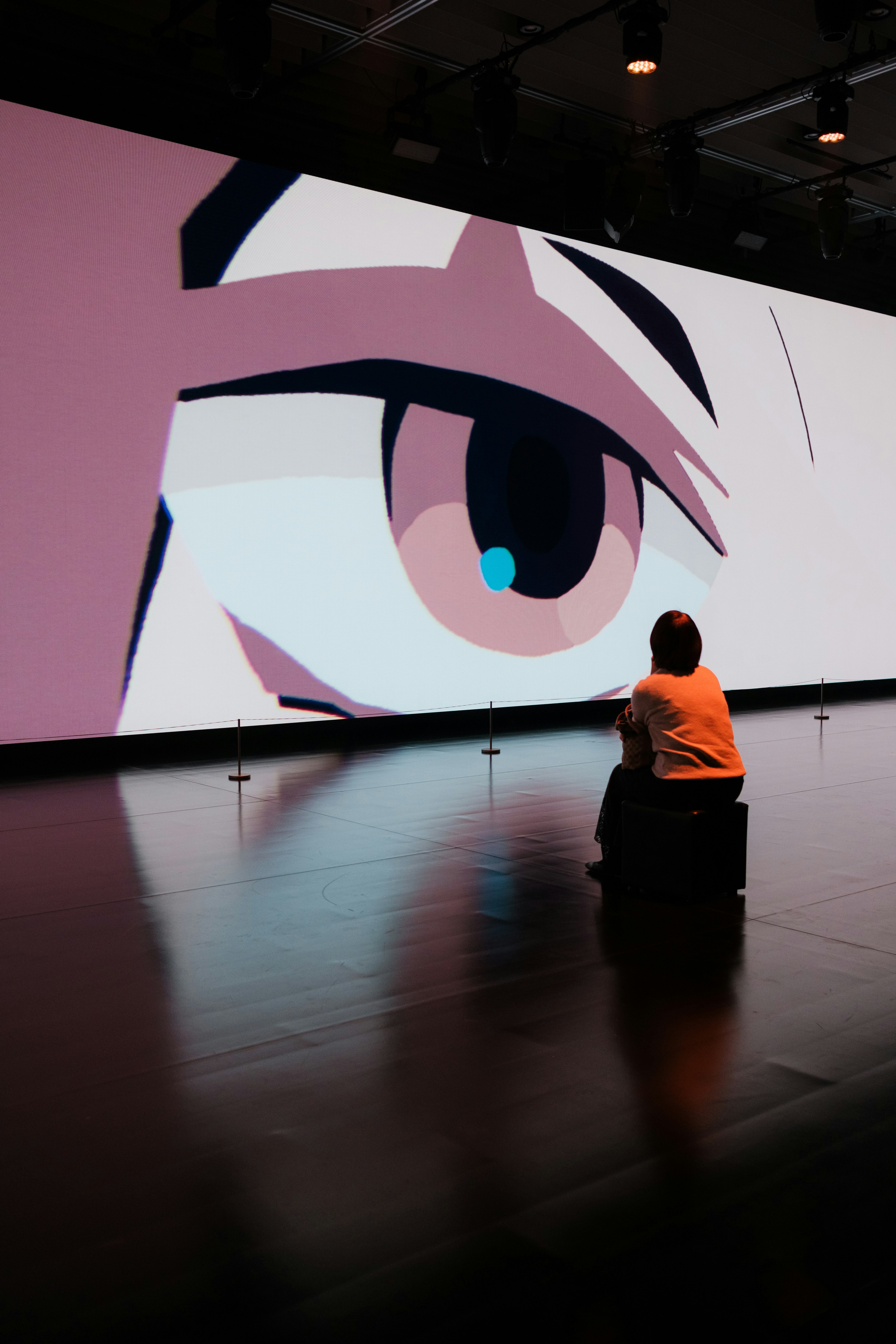 A viewer gazing at a large animated eye on a screen