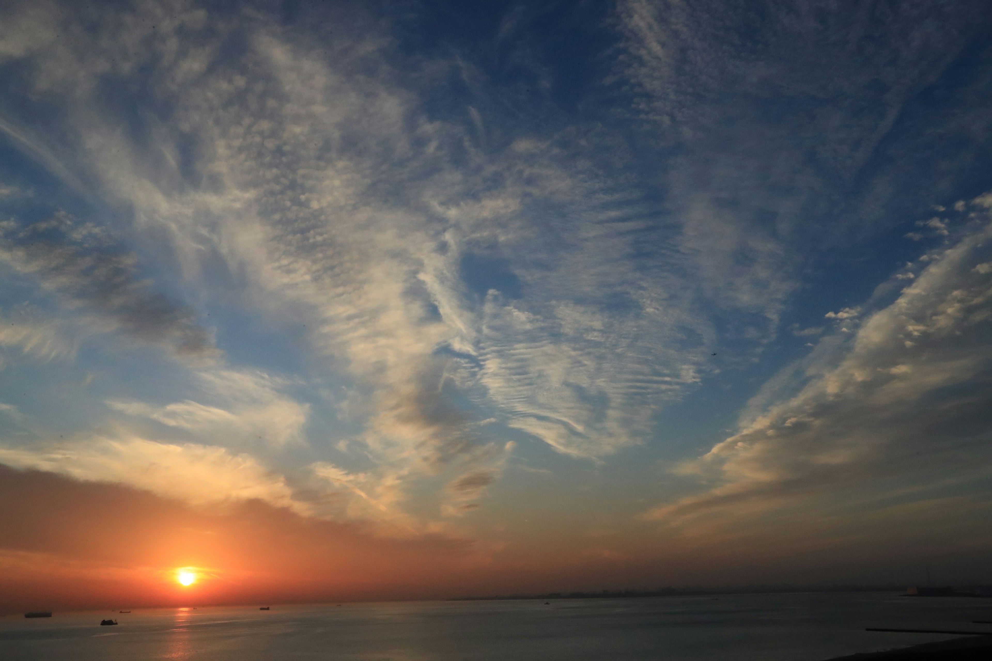 Matahari terbenam yang indah dengan langit biru dan awan tersebar