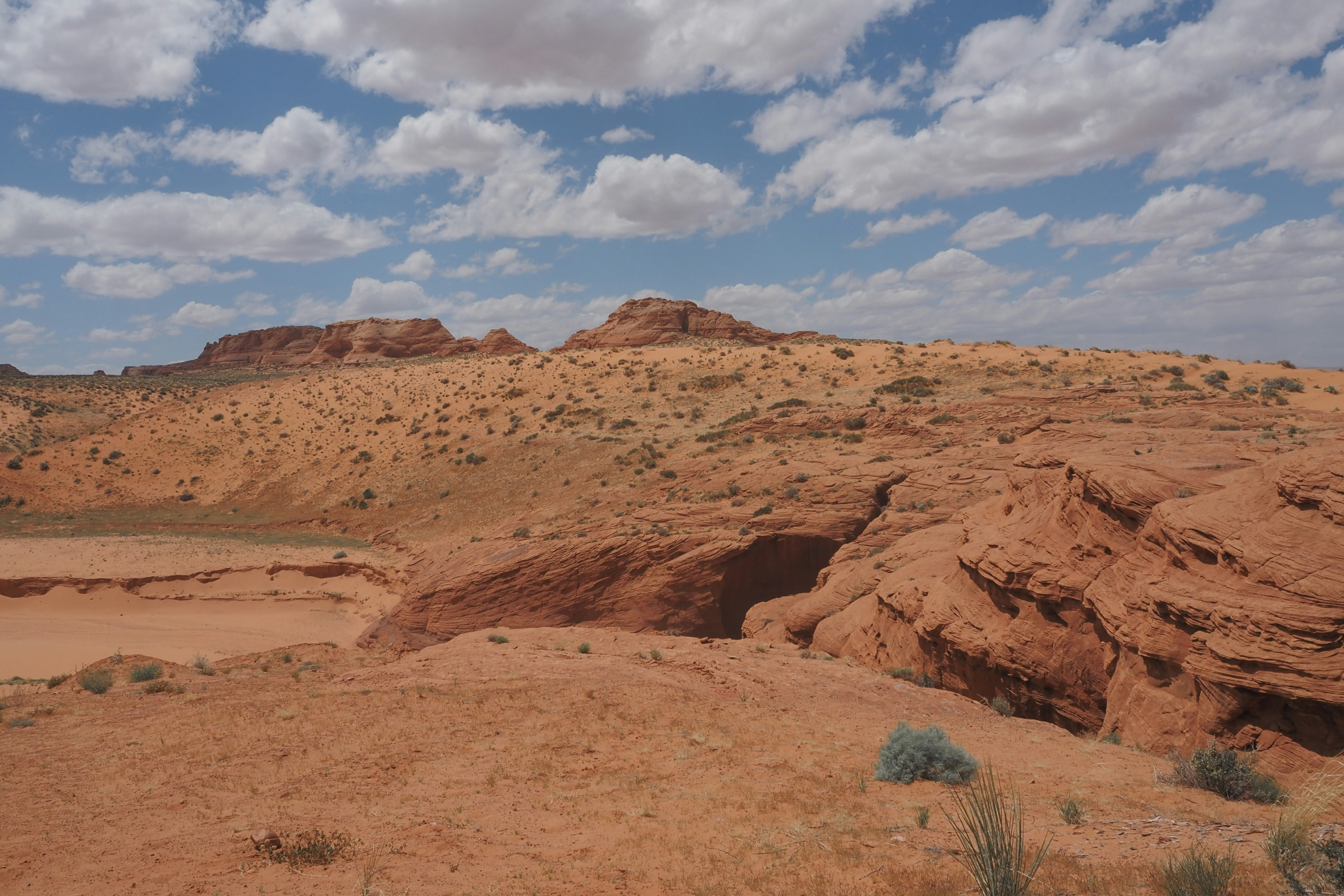 Expansive red desert landscape with scattered clouds