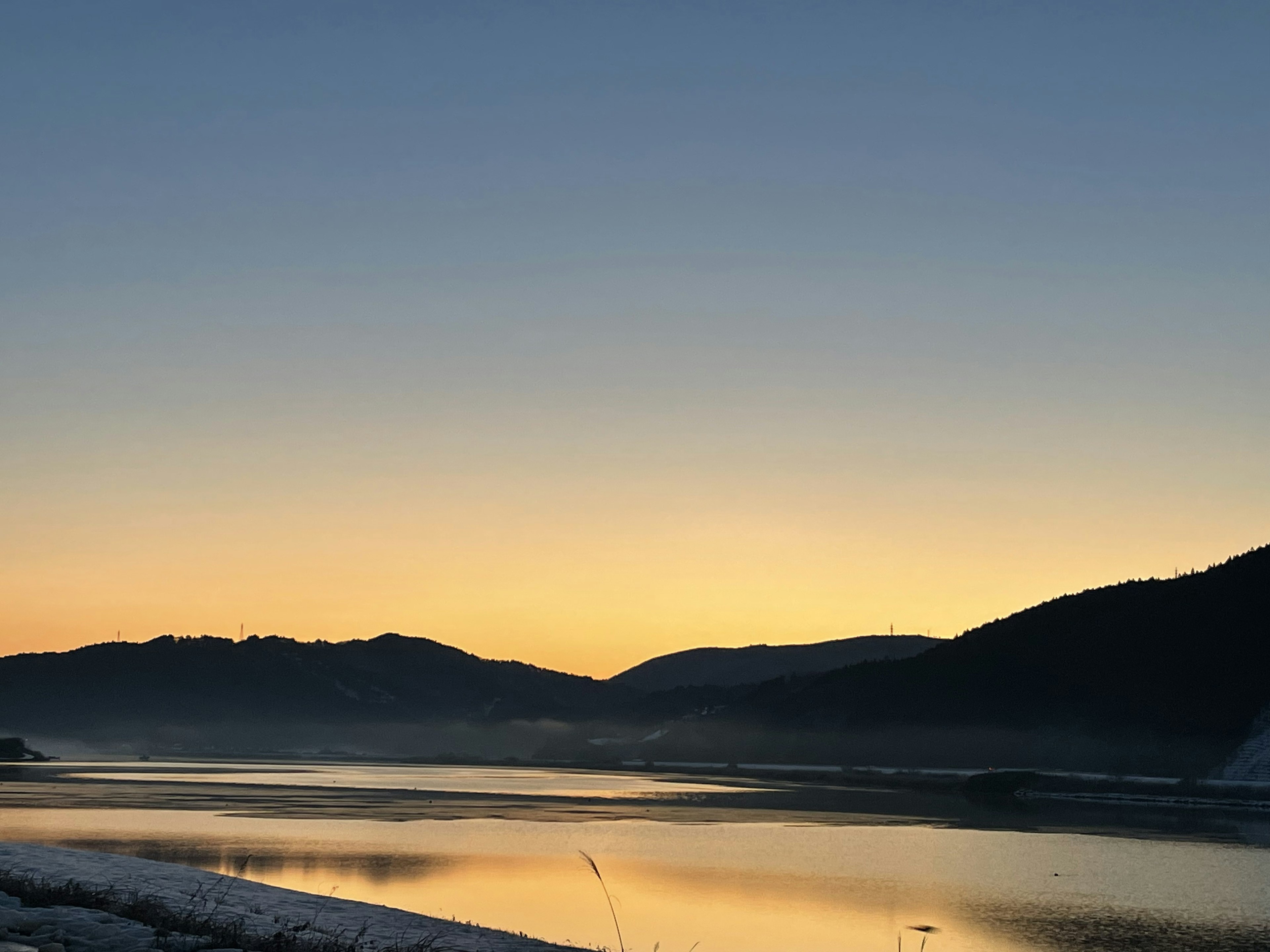 静かな湖と山々の美しい夕焼け