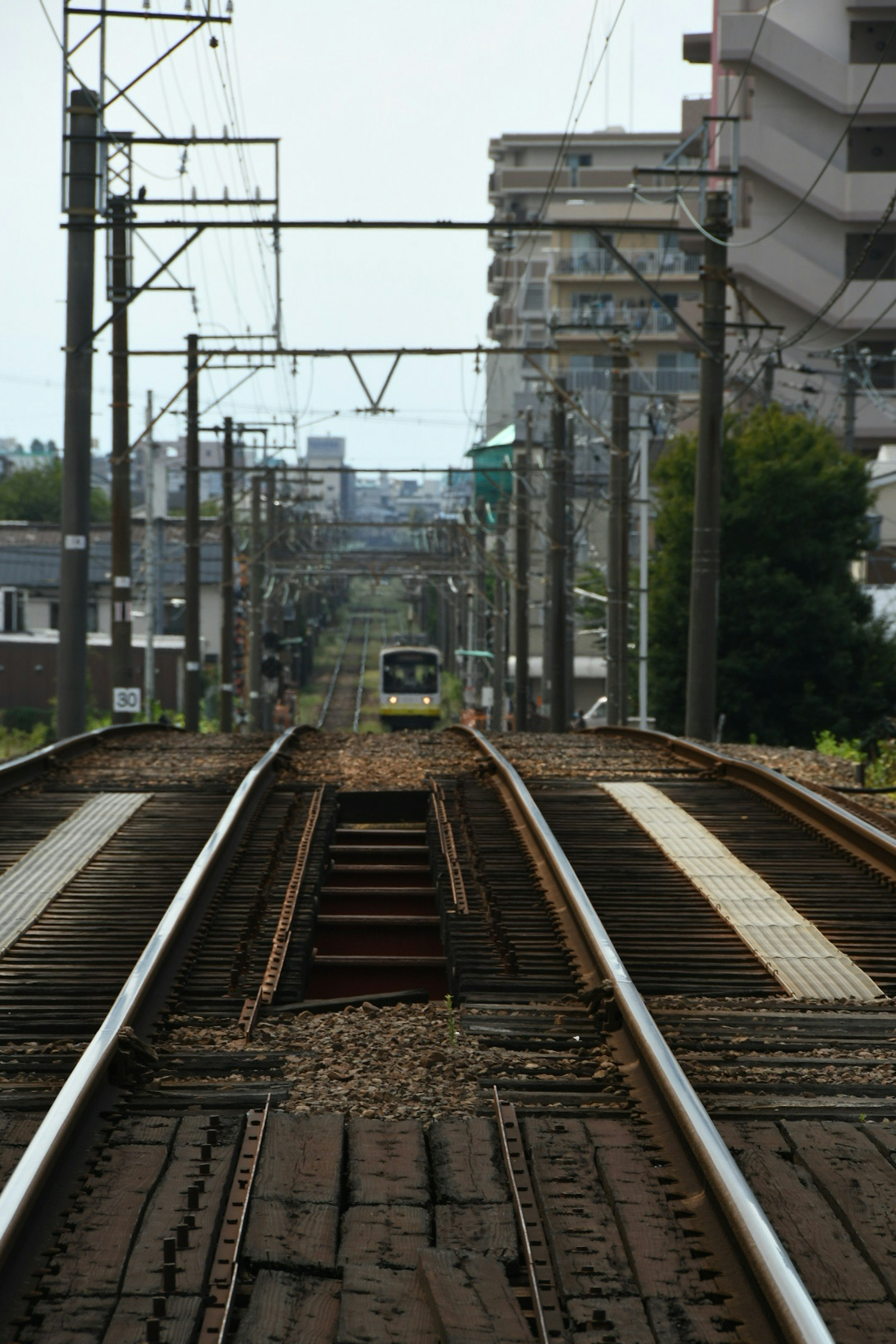 รางรถไฟที่ยาวไปในระยะไกลพร้อมกับรถไฟที่กำลังมาถึง