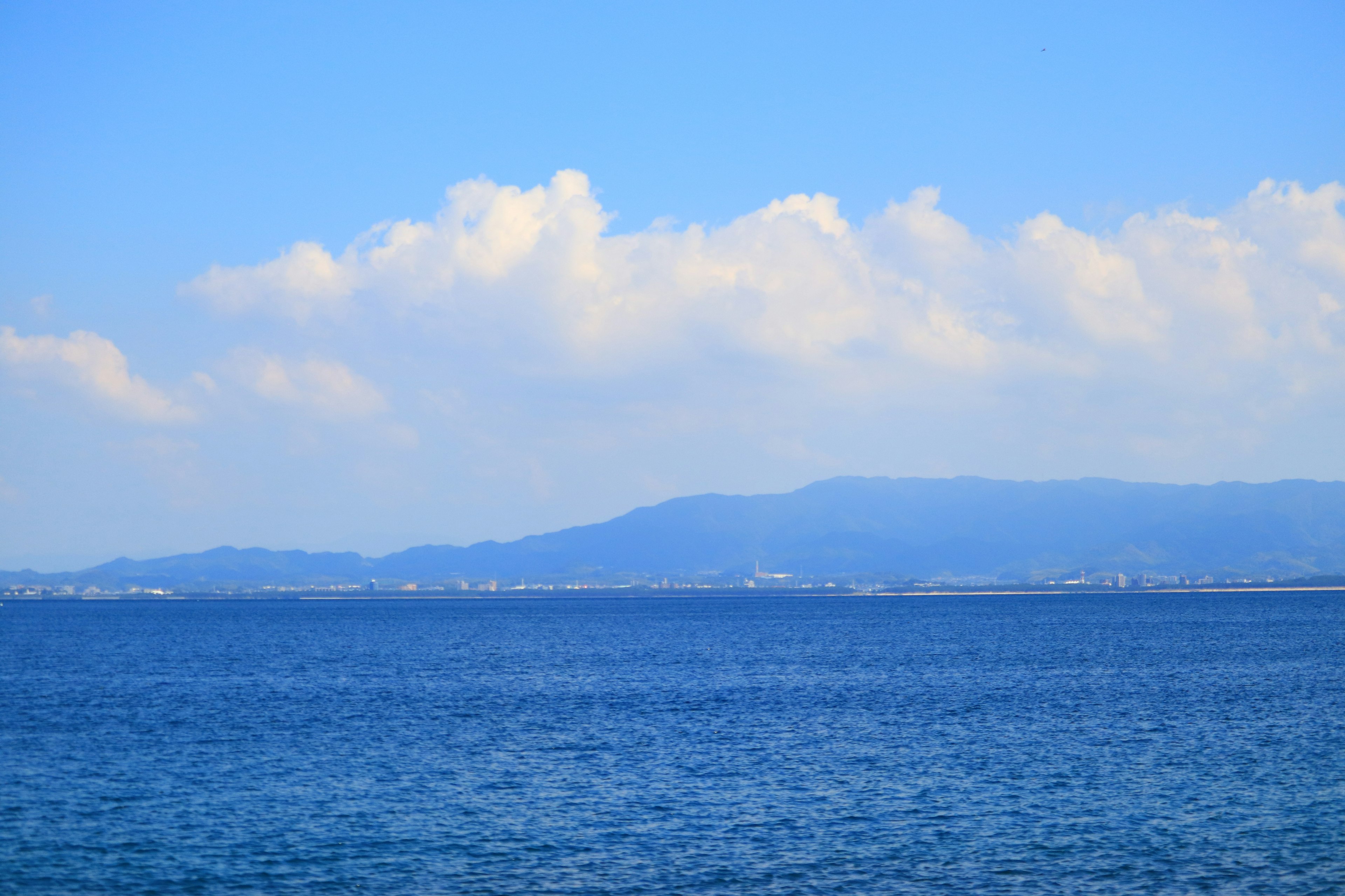 美丽的海景，蓝色的海洋和天空，背景是山的轮廓