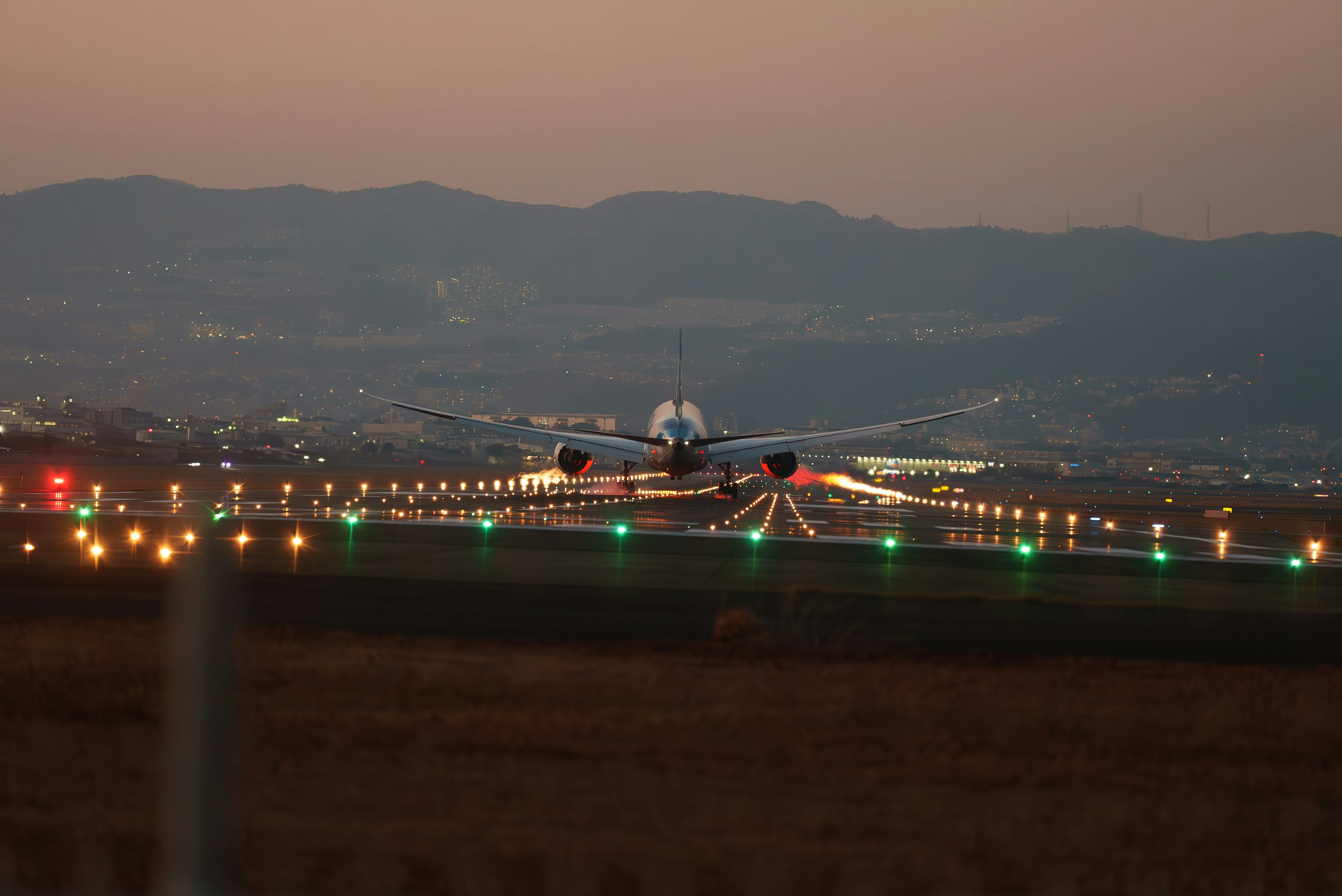 Ein Flugzeug landet auf einer Landebahn während der Dämmerung