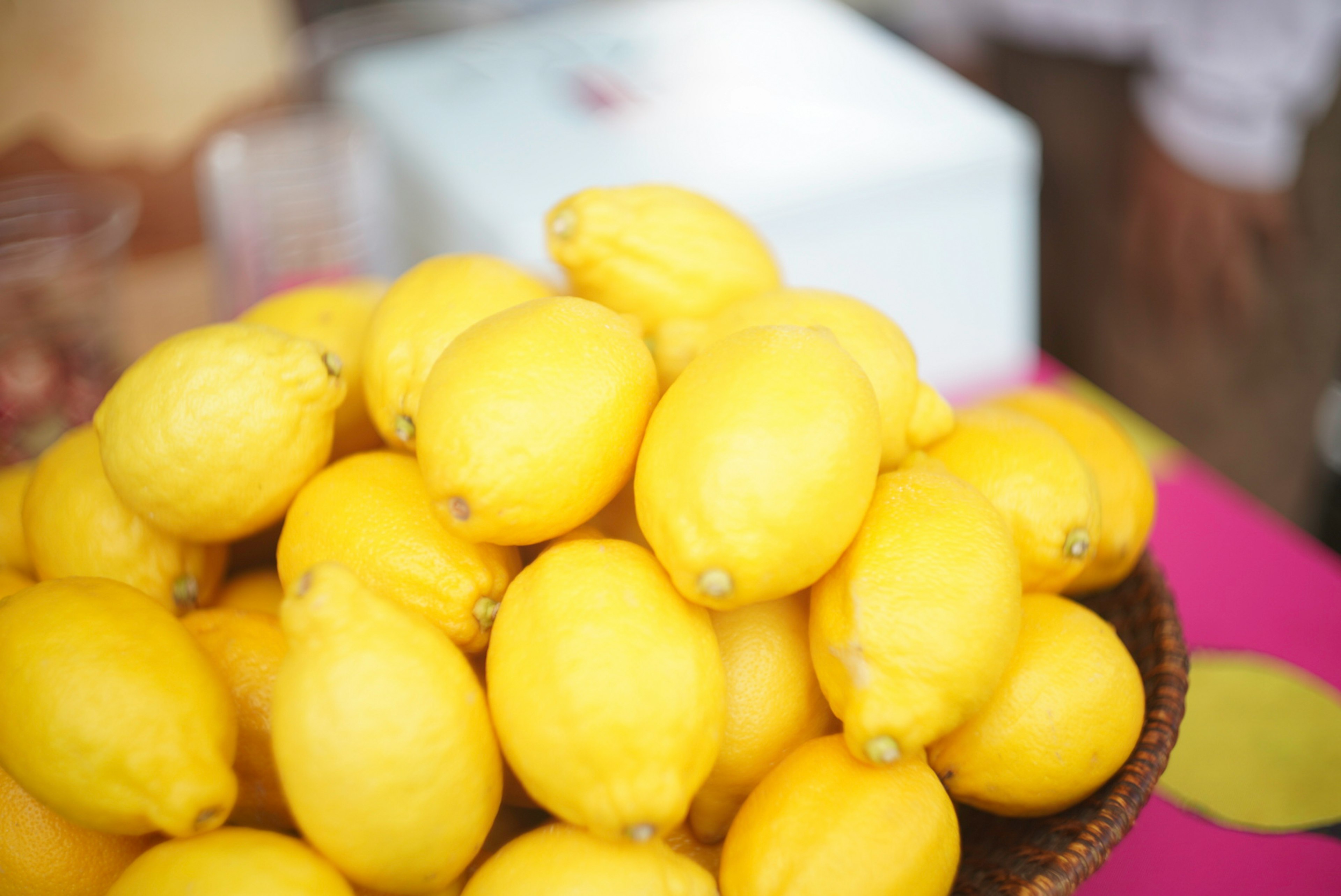 Tumpukan lemon kuning yang cerah dalam keranjang