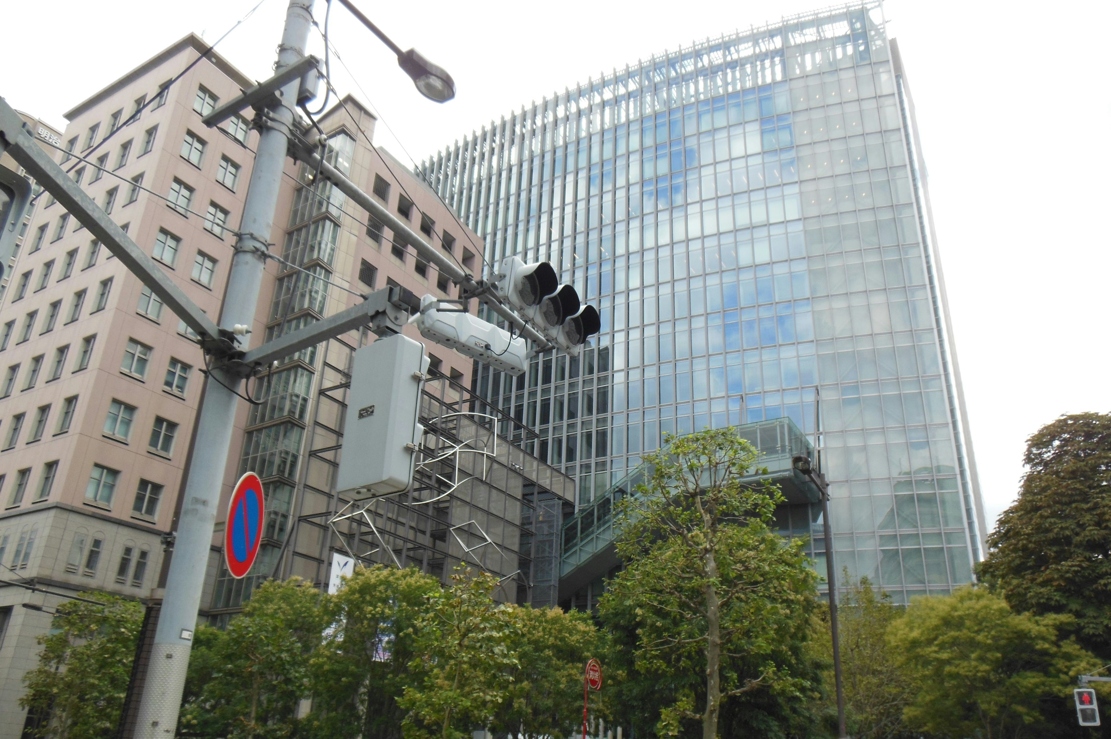 Edificio moderno de vidrio con semáforos y vegetación