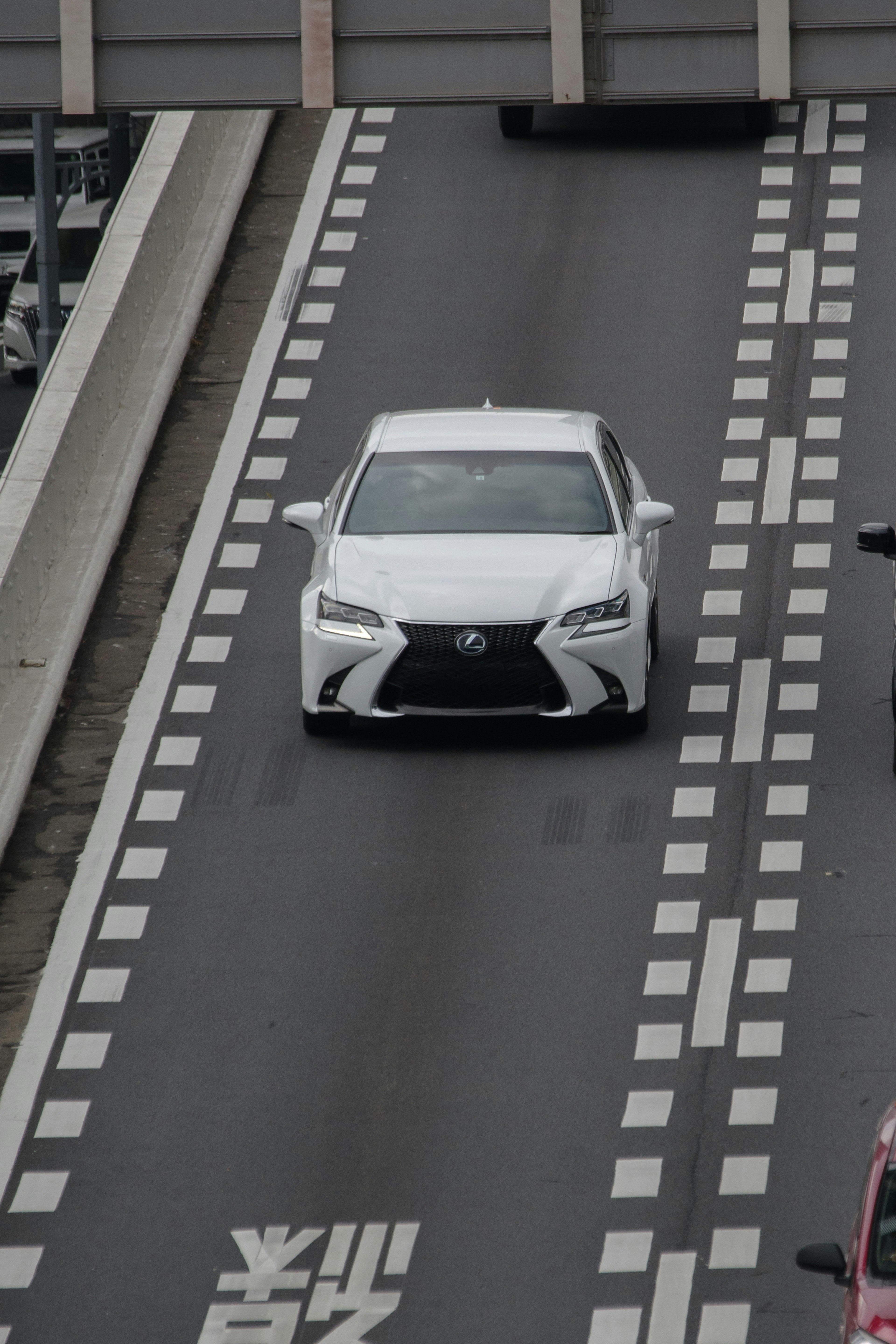 A white Lexus car driving on a highway