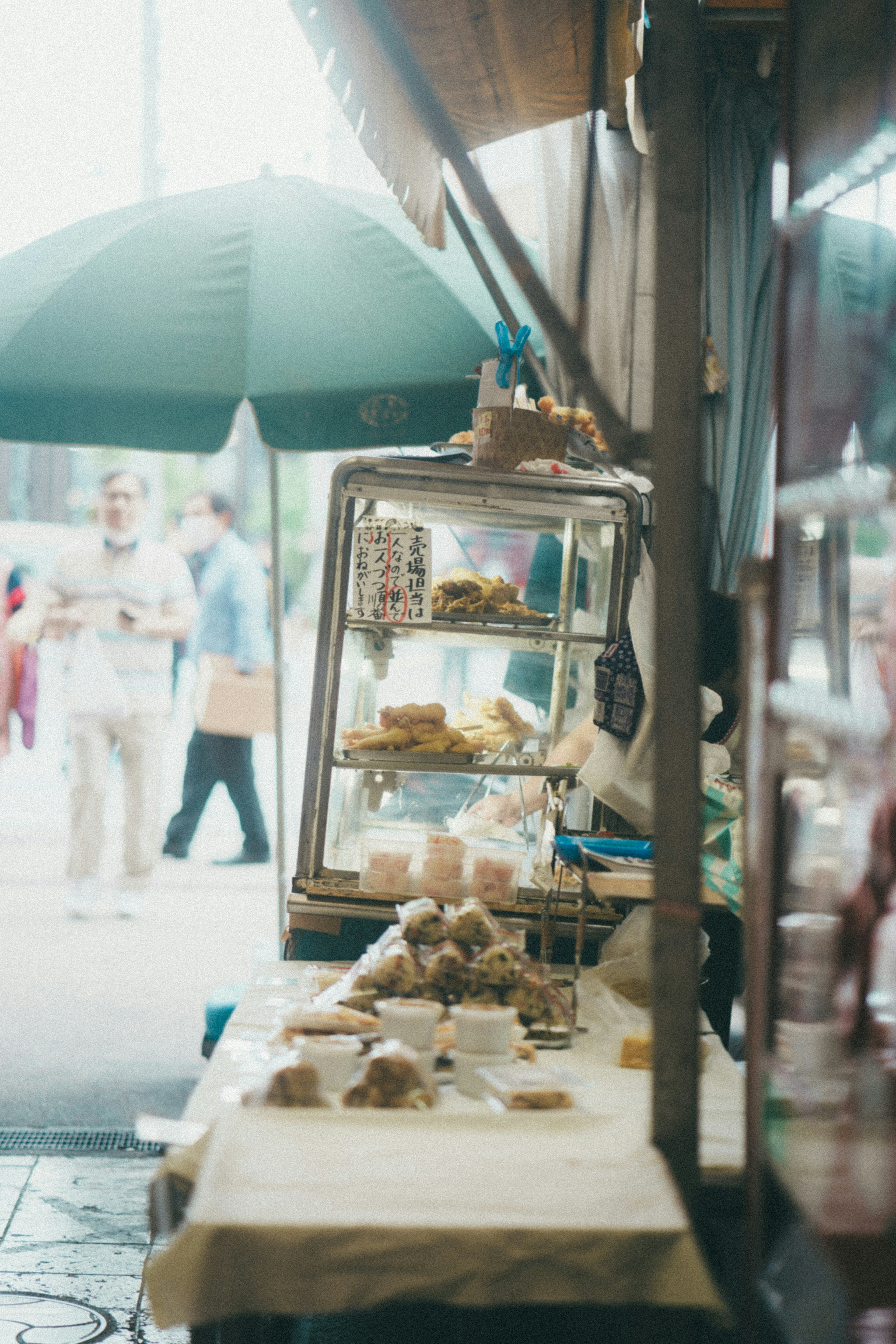 Street vendor display with food items and green umbrella