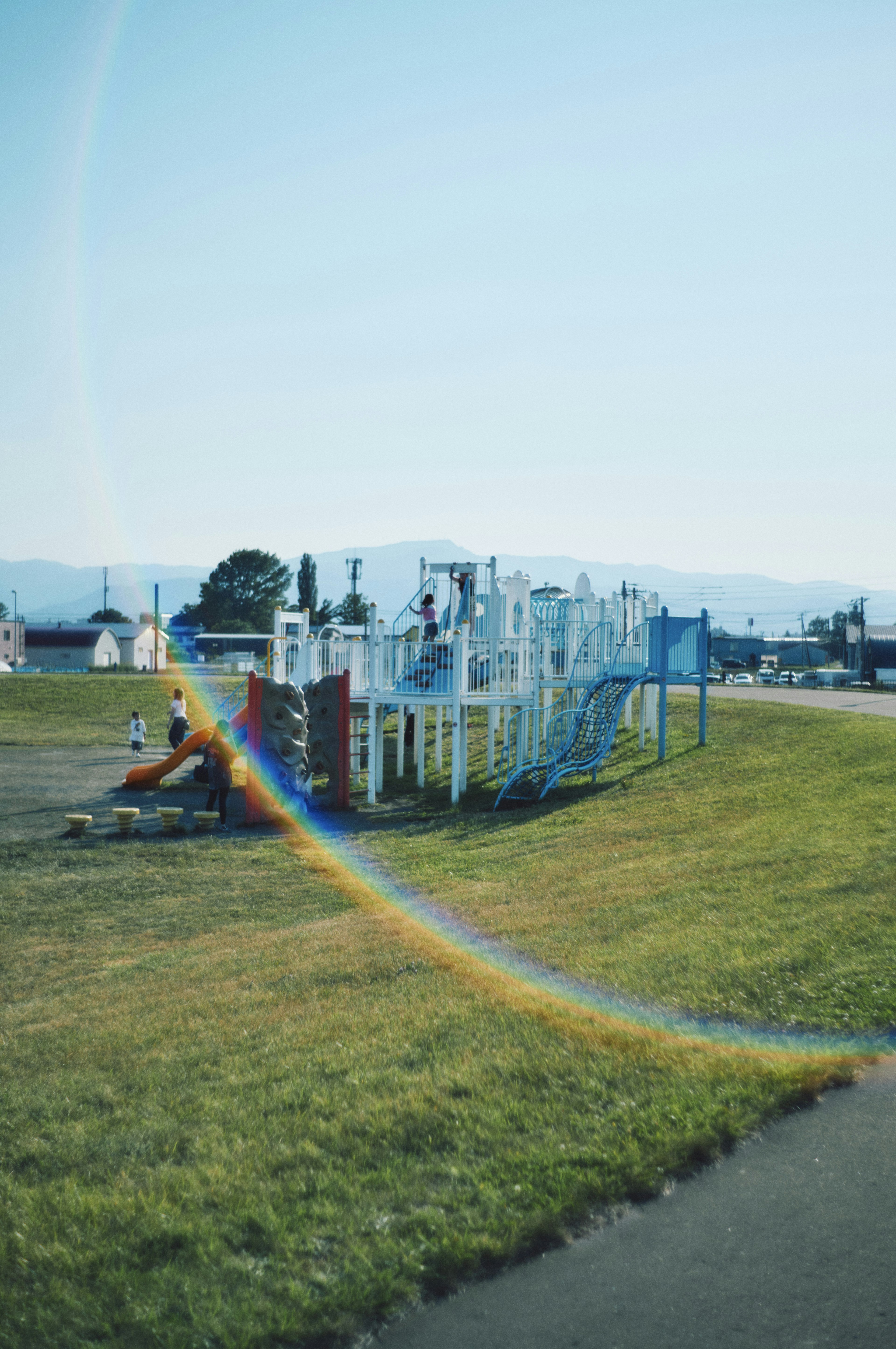 Spielplatzgeräte in einem Park unter einem klaren blauen Himmel