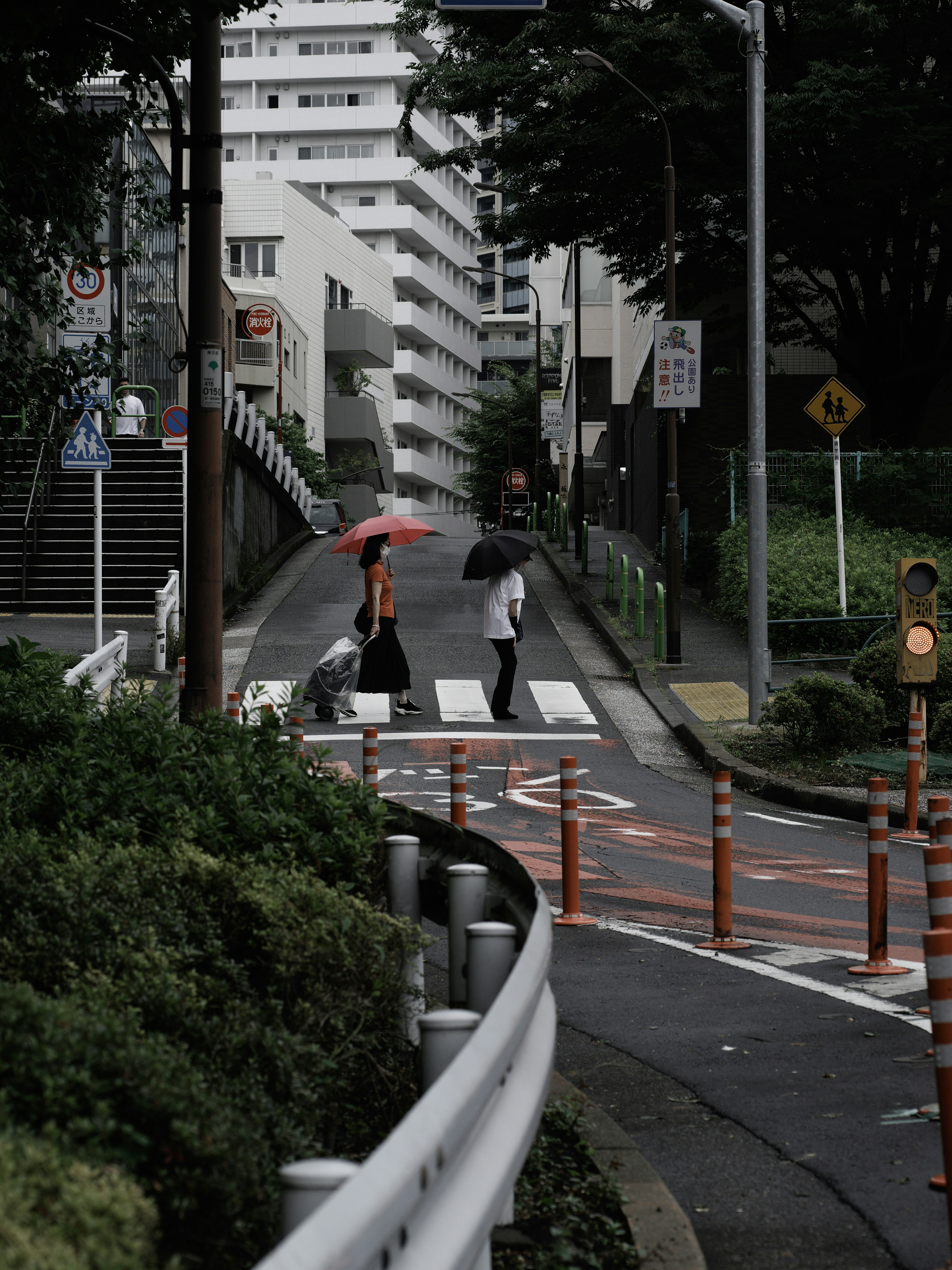 People crossing a street with an umbrella in an urban setting