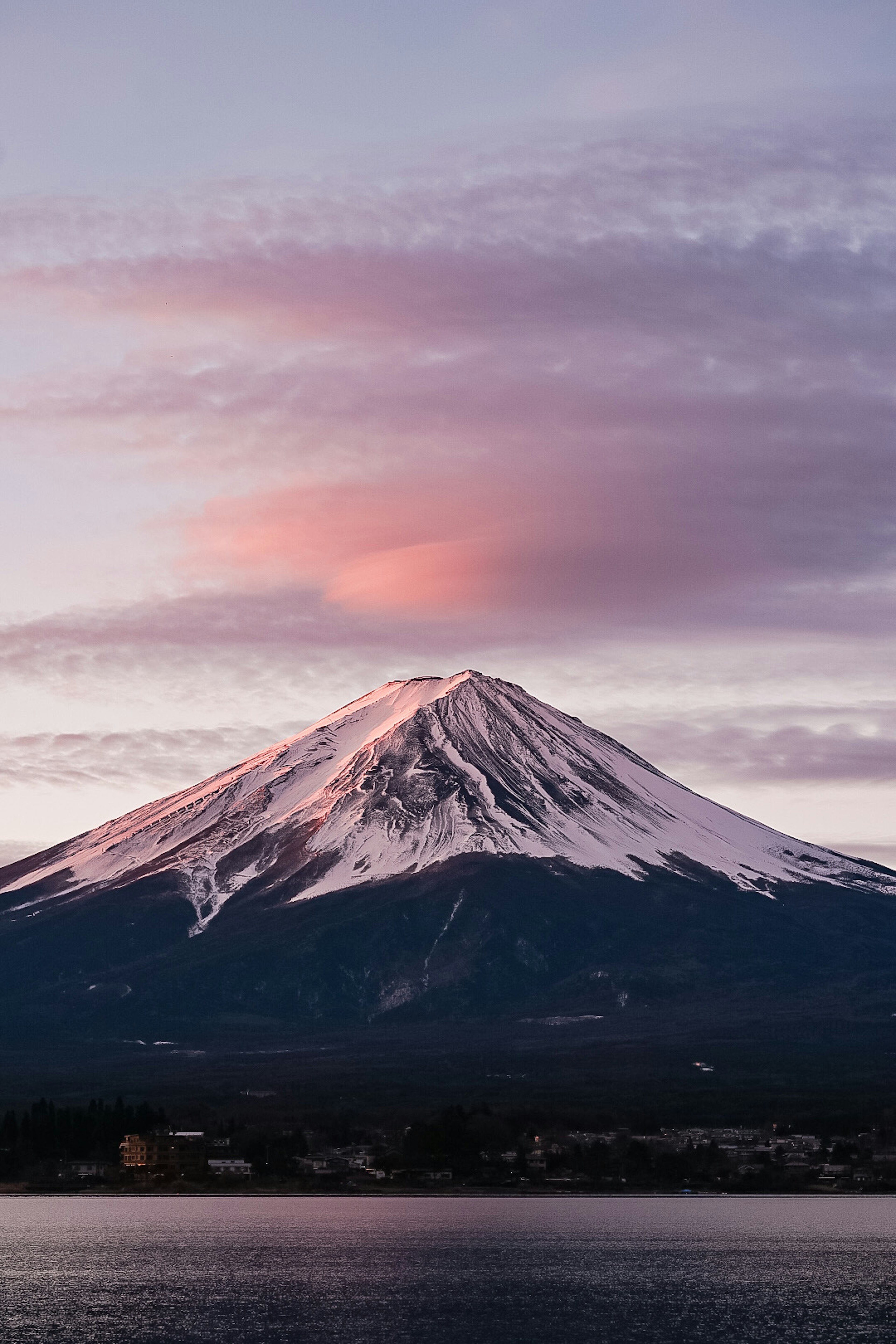 富士山の雪に覆われた頂上と夕焼けに染まる雲