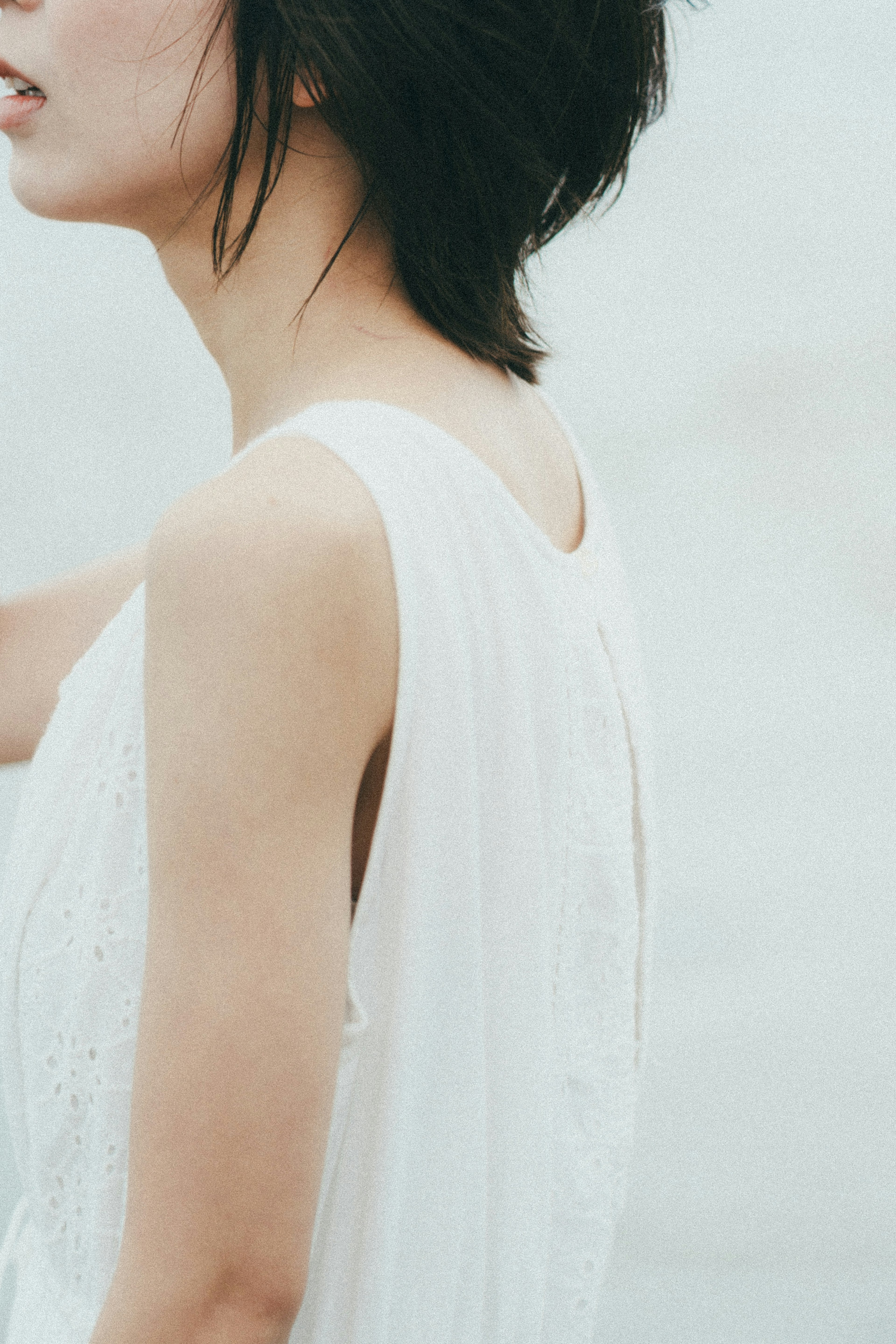 Profil einer Frau in einem weißen Kleid vor einem sanften Hintergrund