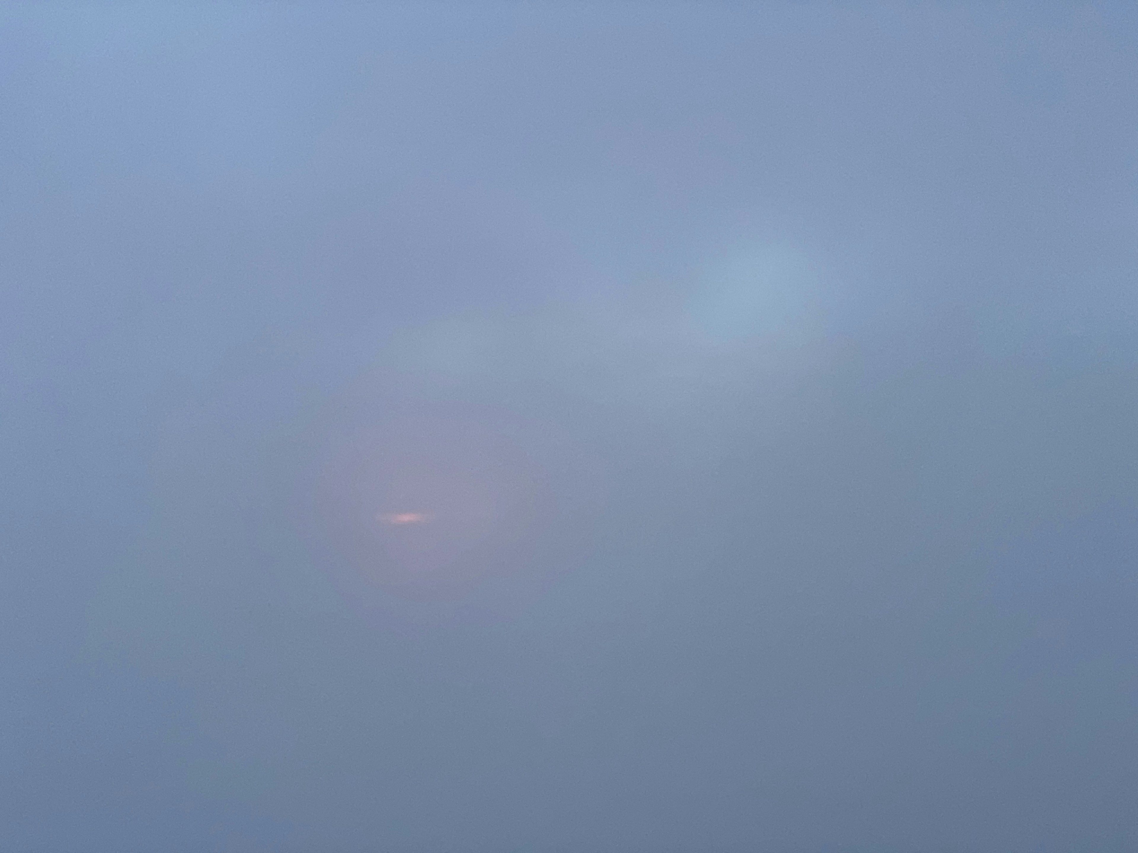 A faint light visible in a foggy landscape