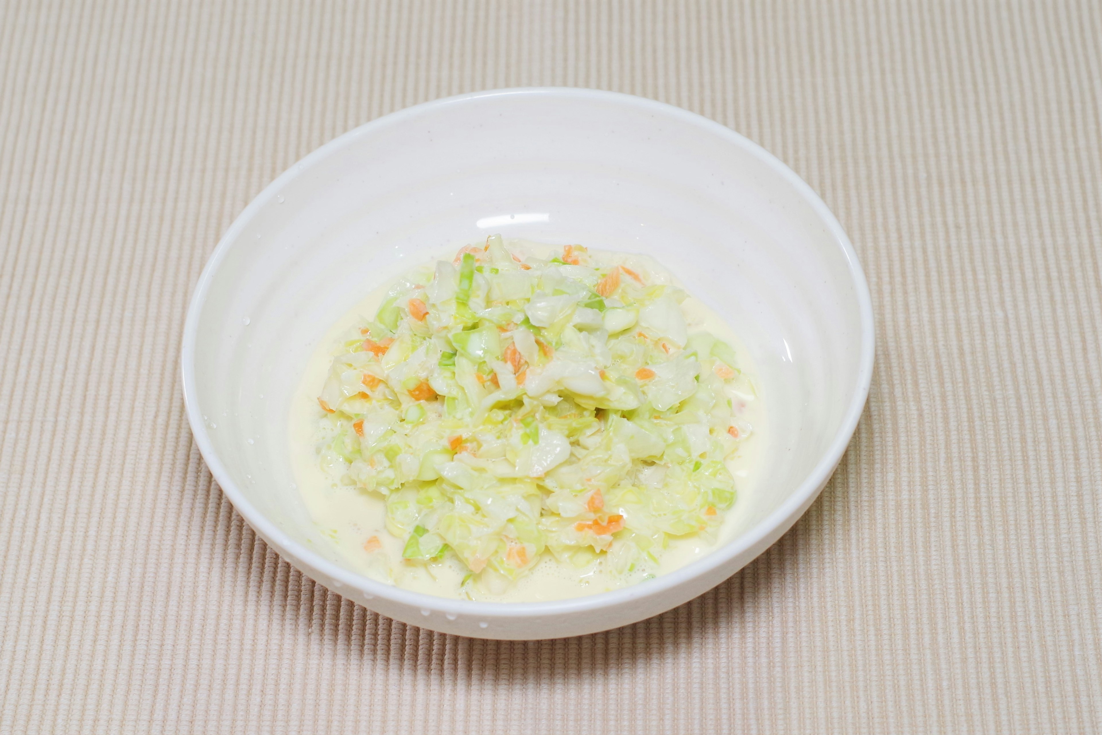 Salad coleslaw với bắp cải và cà rốt trong bát trắng