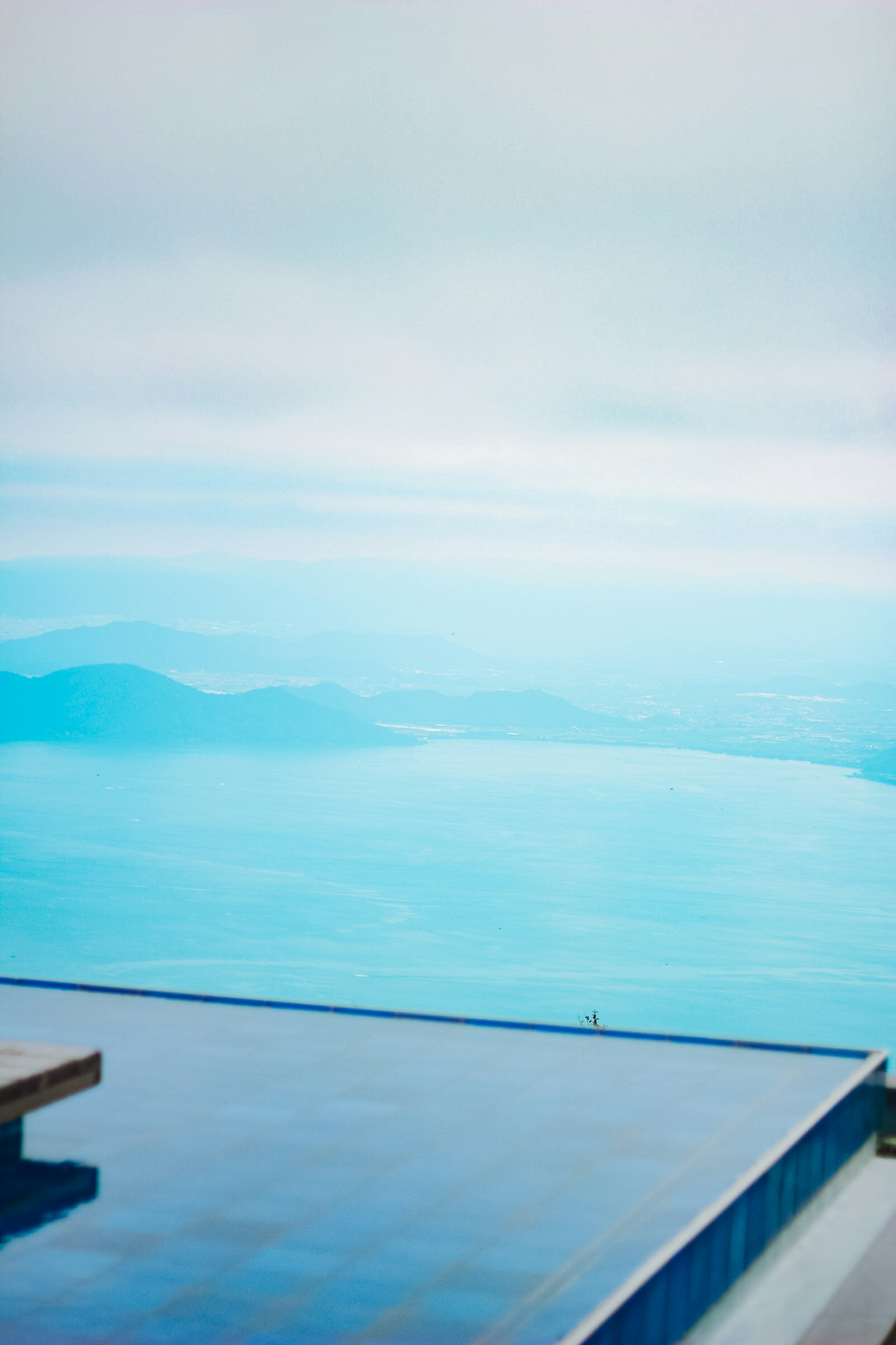 Paysage bleu vaste avec de l'eau et le ciel et une terrasse de piscine