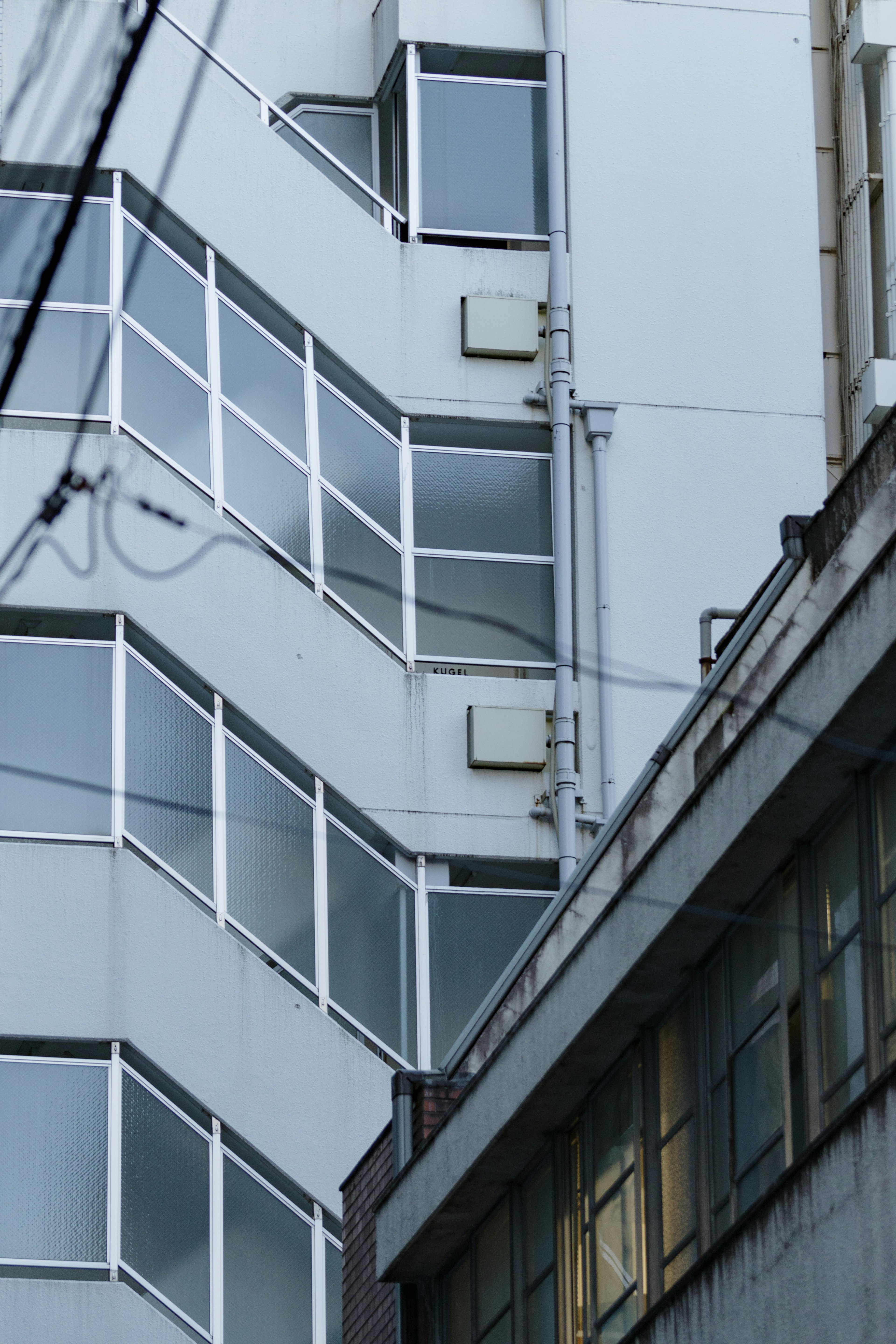 Partie d'un bâtiment moderne avec des fenêtres en verre bleu et des unités de climatisation