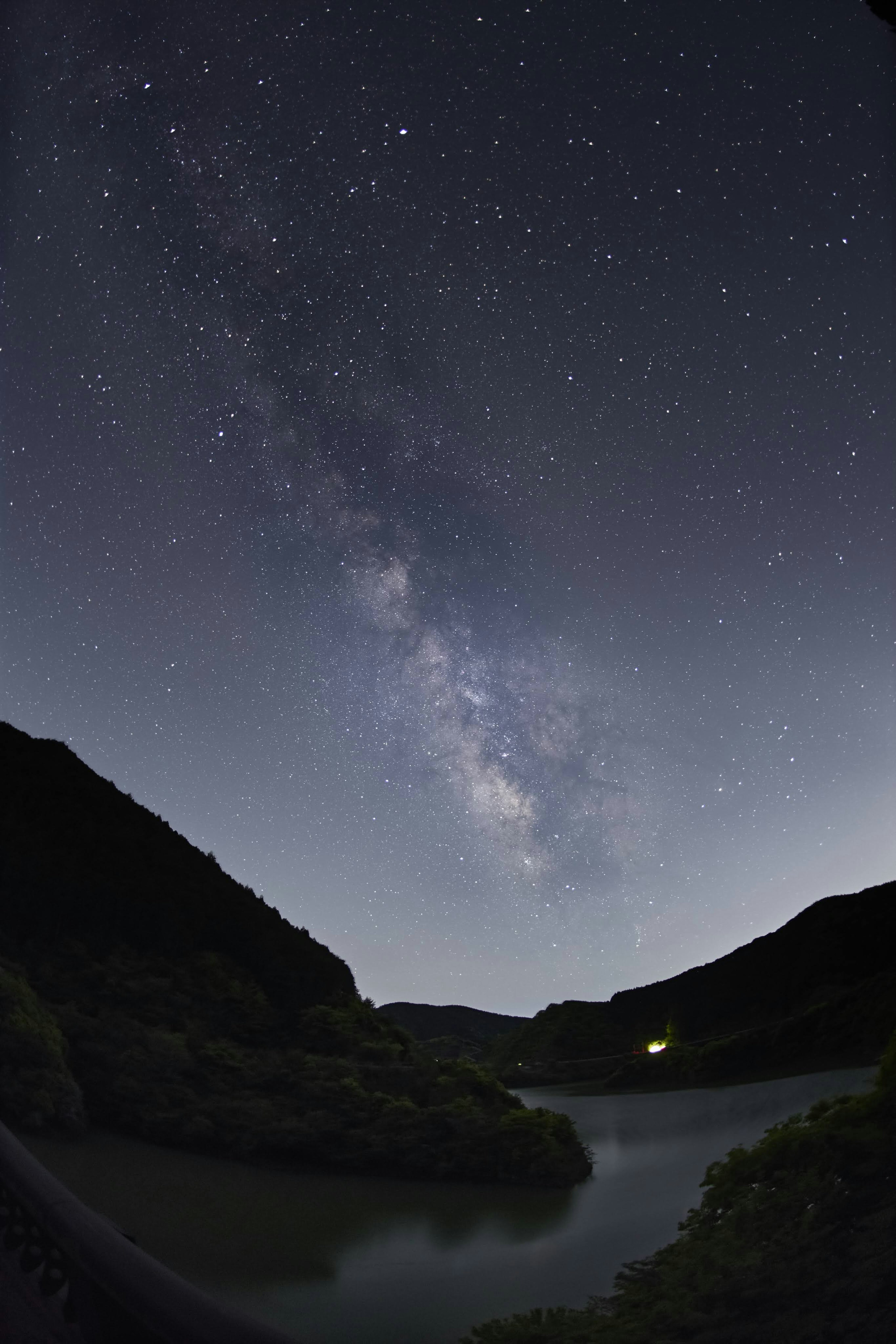 Cielo nocturno estrellado con la Vía Láctea visible sobre un paisaje tranquilo