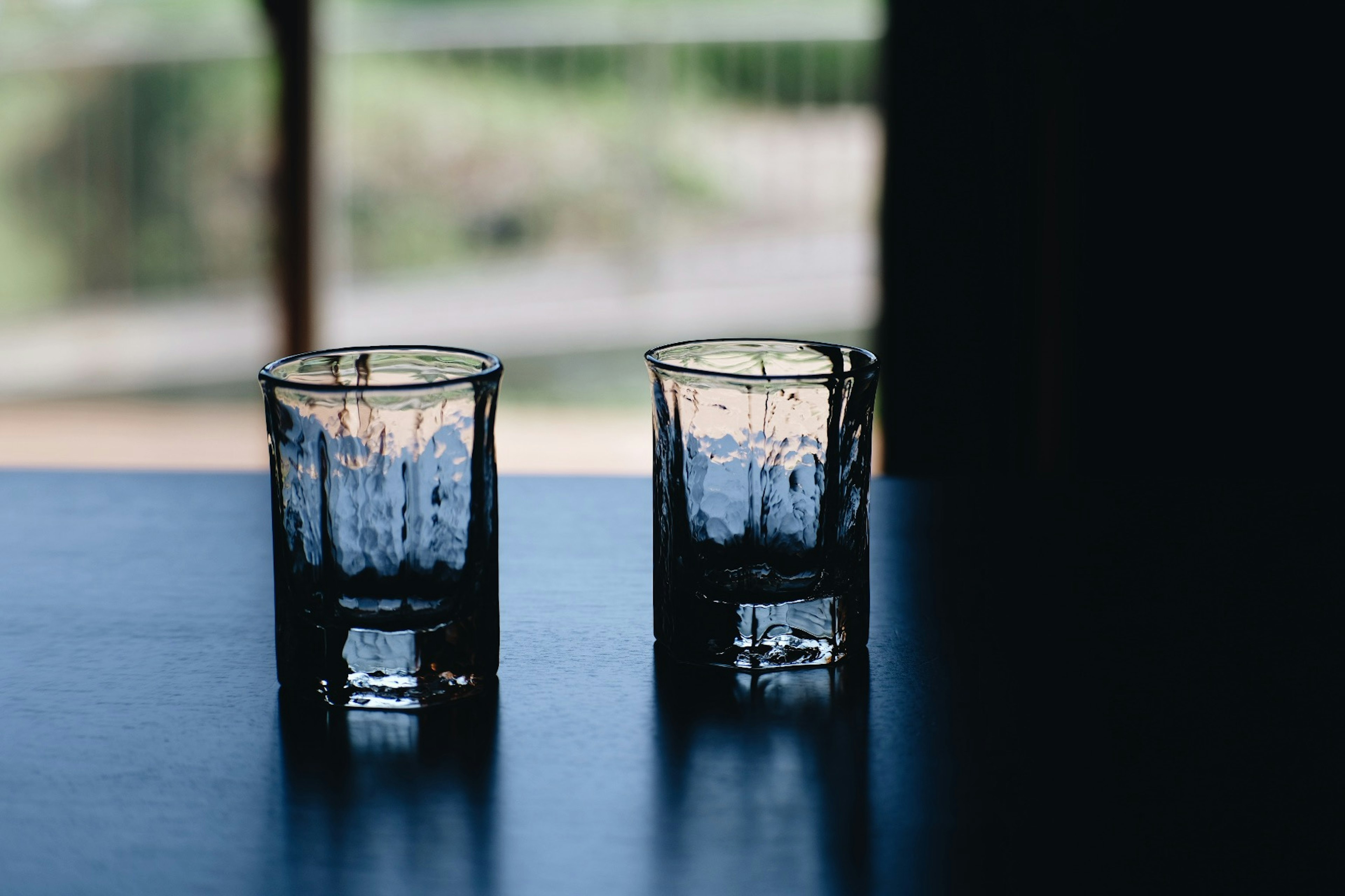 Two decorative glass cups on a table with a blurred background