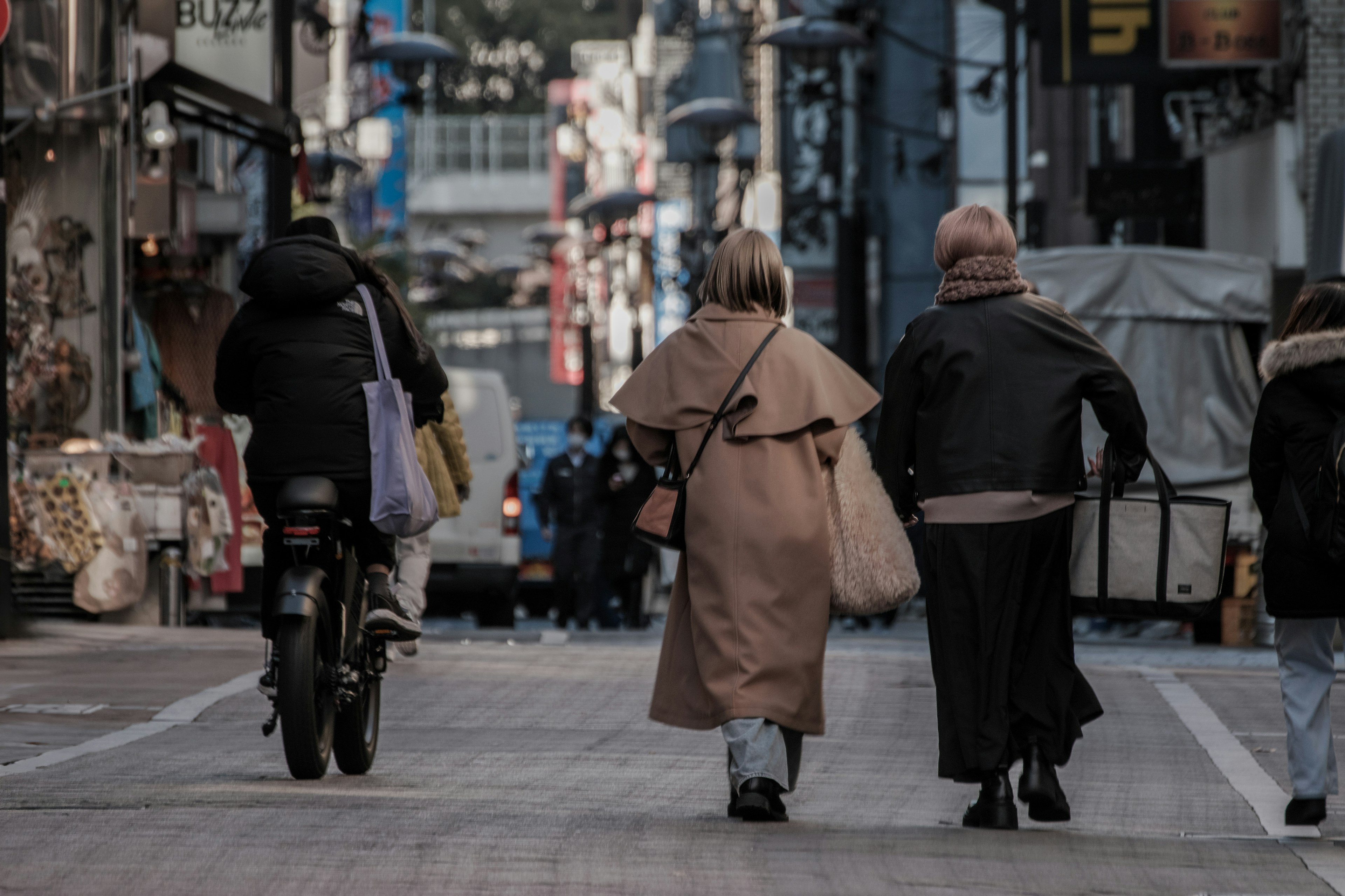 Personas caminando por una calle con una motocicleta de fondo