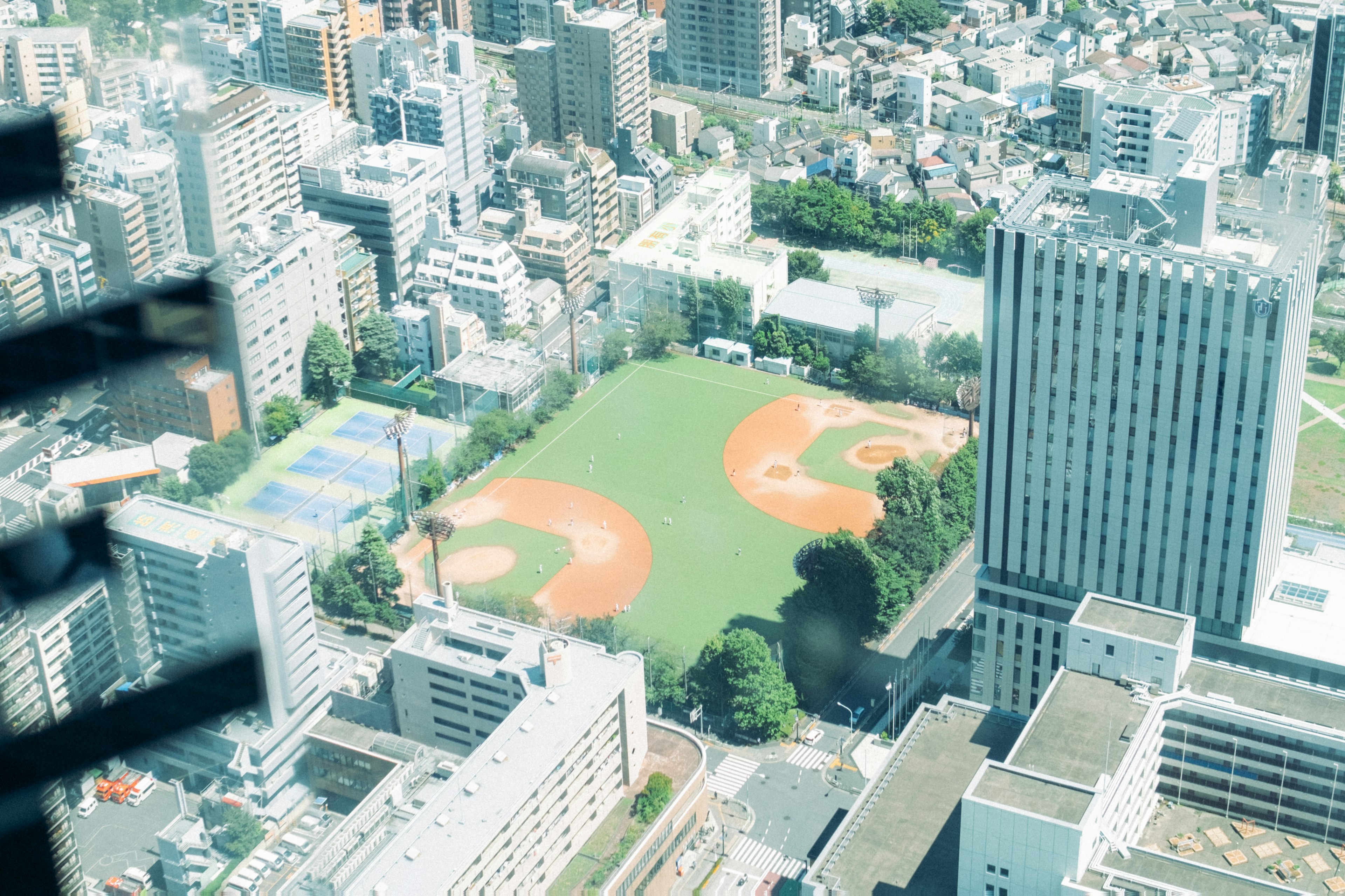 高層ビルから見た野球場のある都市風景