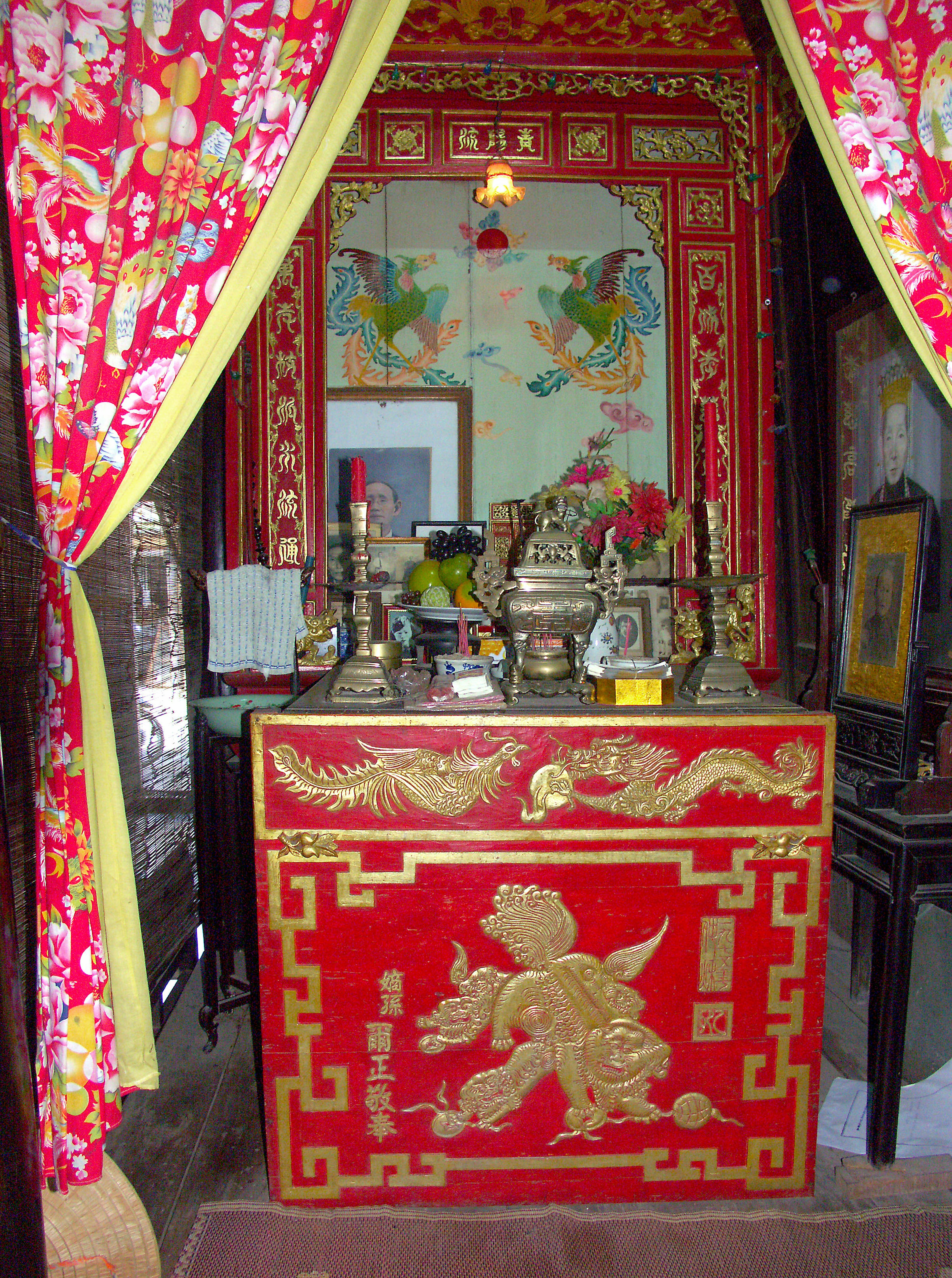 Interior con un altar rojo y una escultura de león dorado con cortinas vibrantes