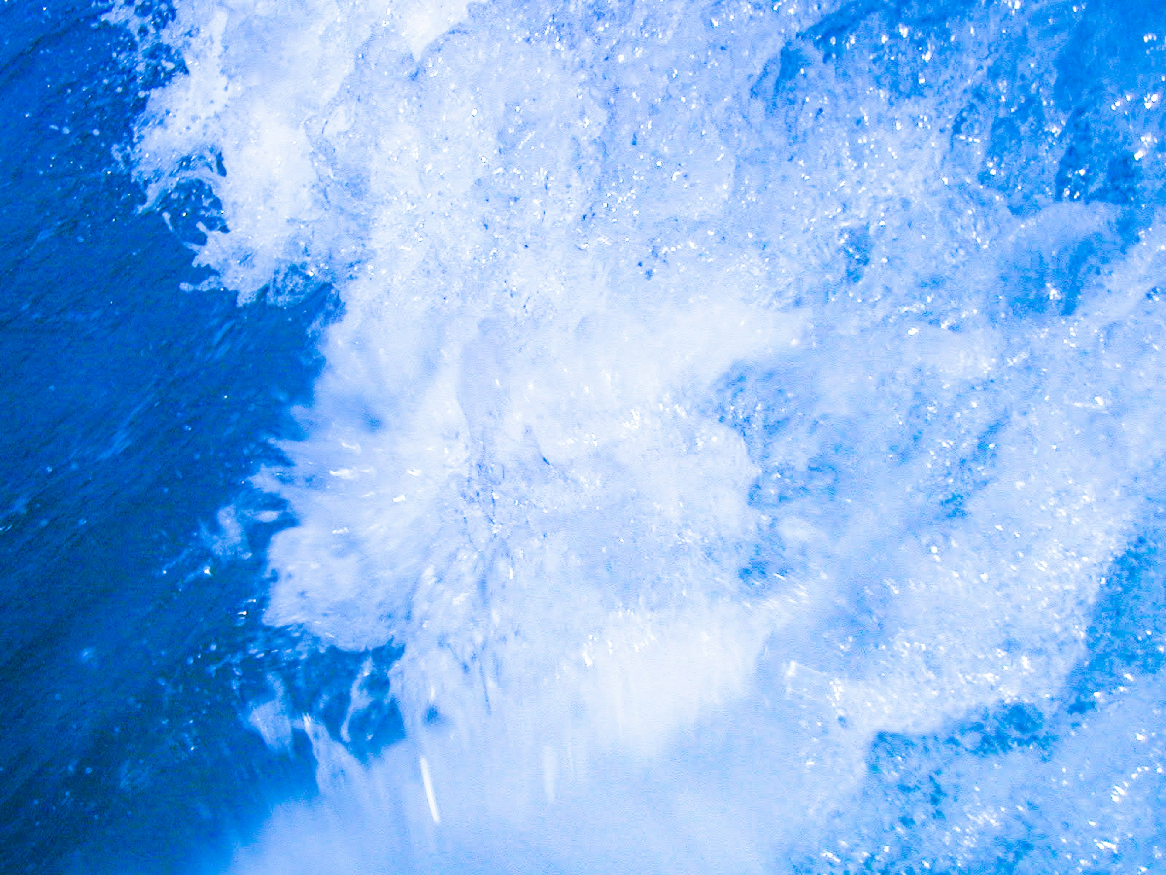 Primo piano di schizzi d'acqua e bolle nell'oceano blu