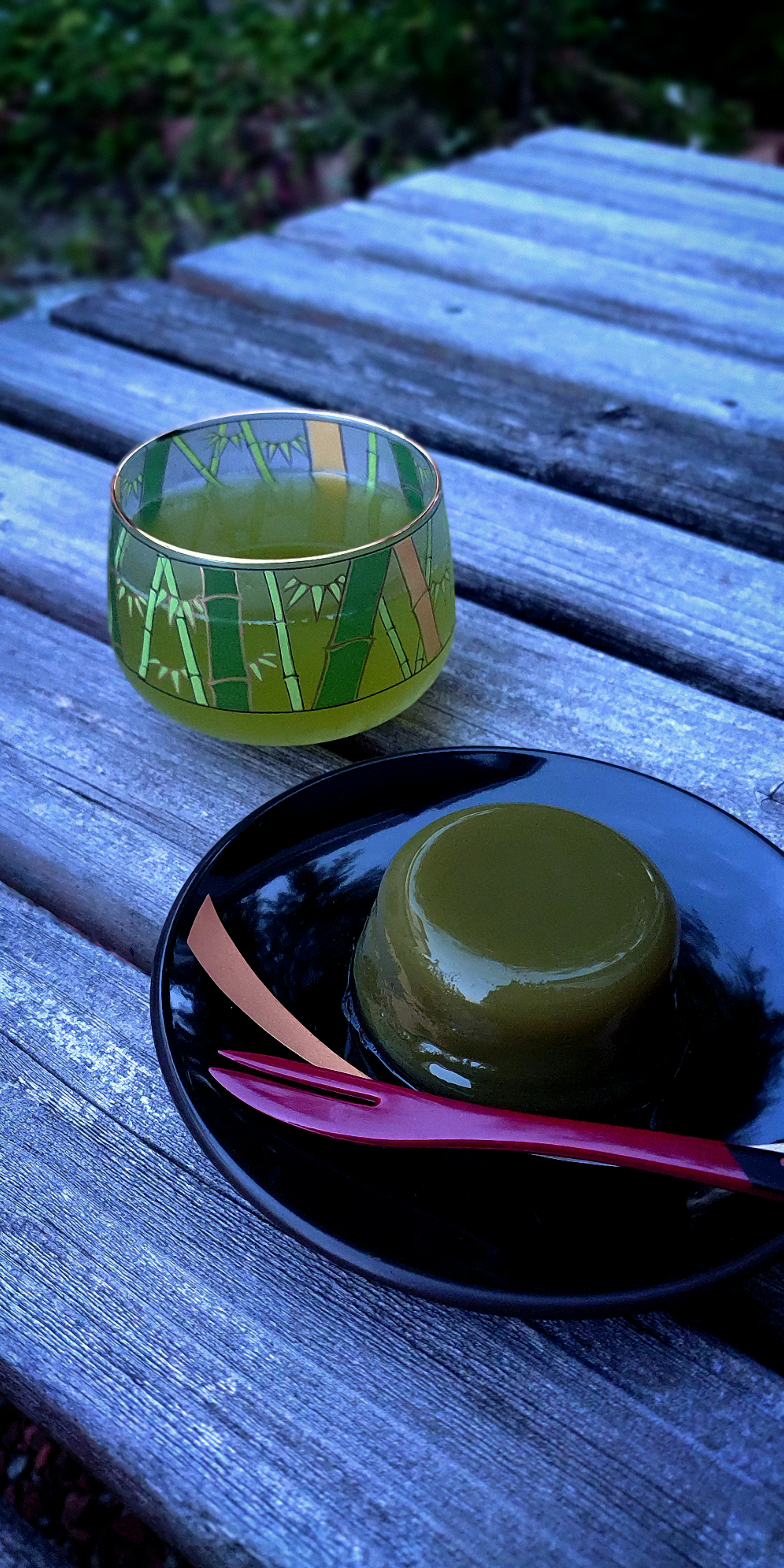 Postre verde y tazón de vidrio sobre una mesa de madera