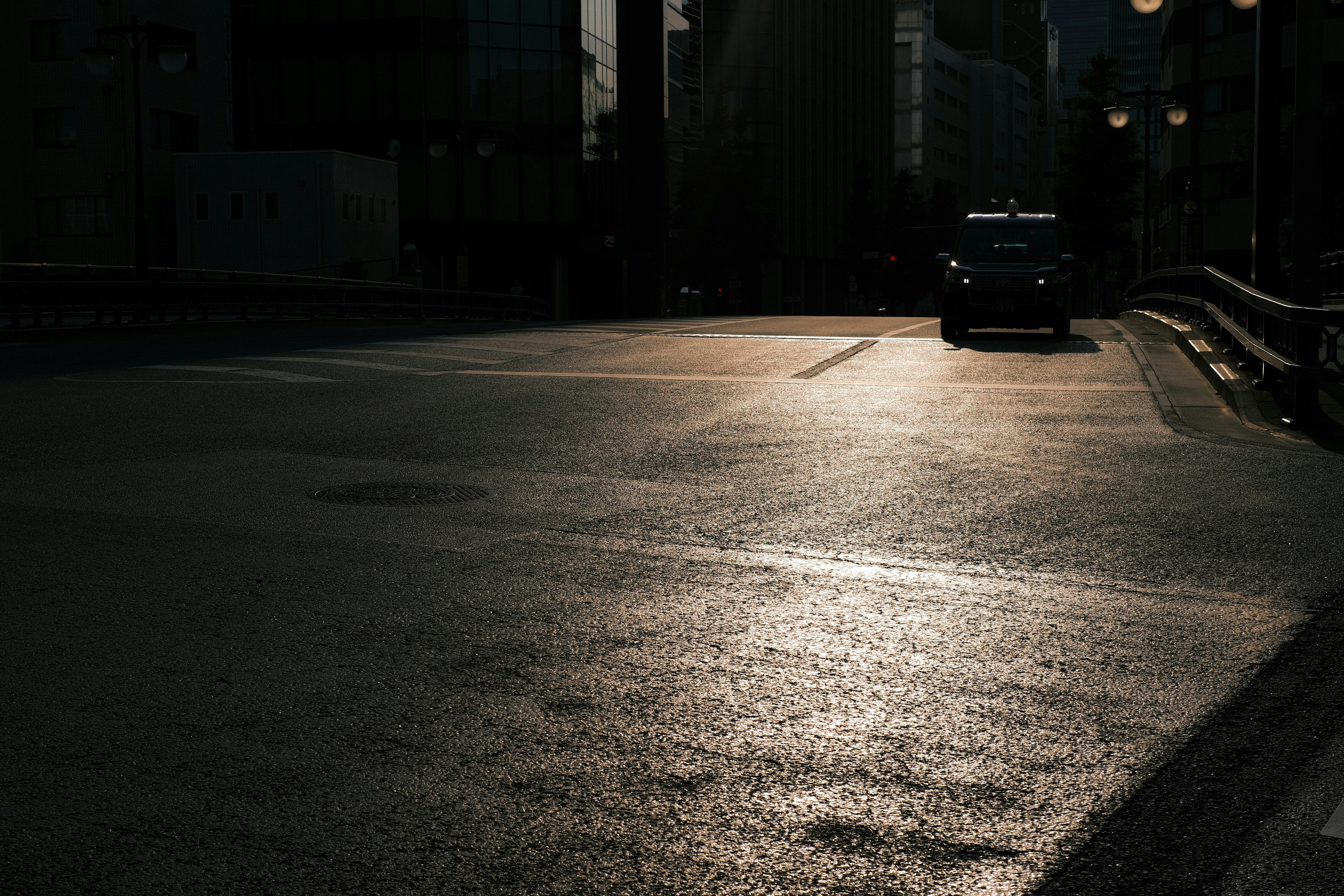 暗い街の道に反射する光と車