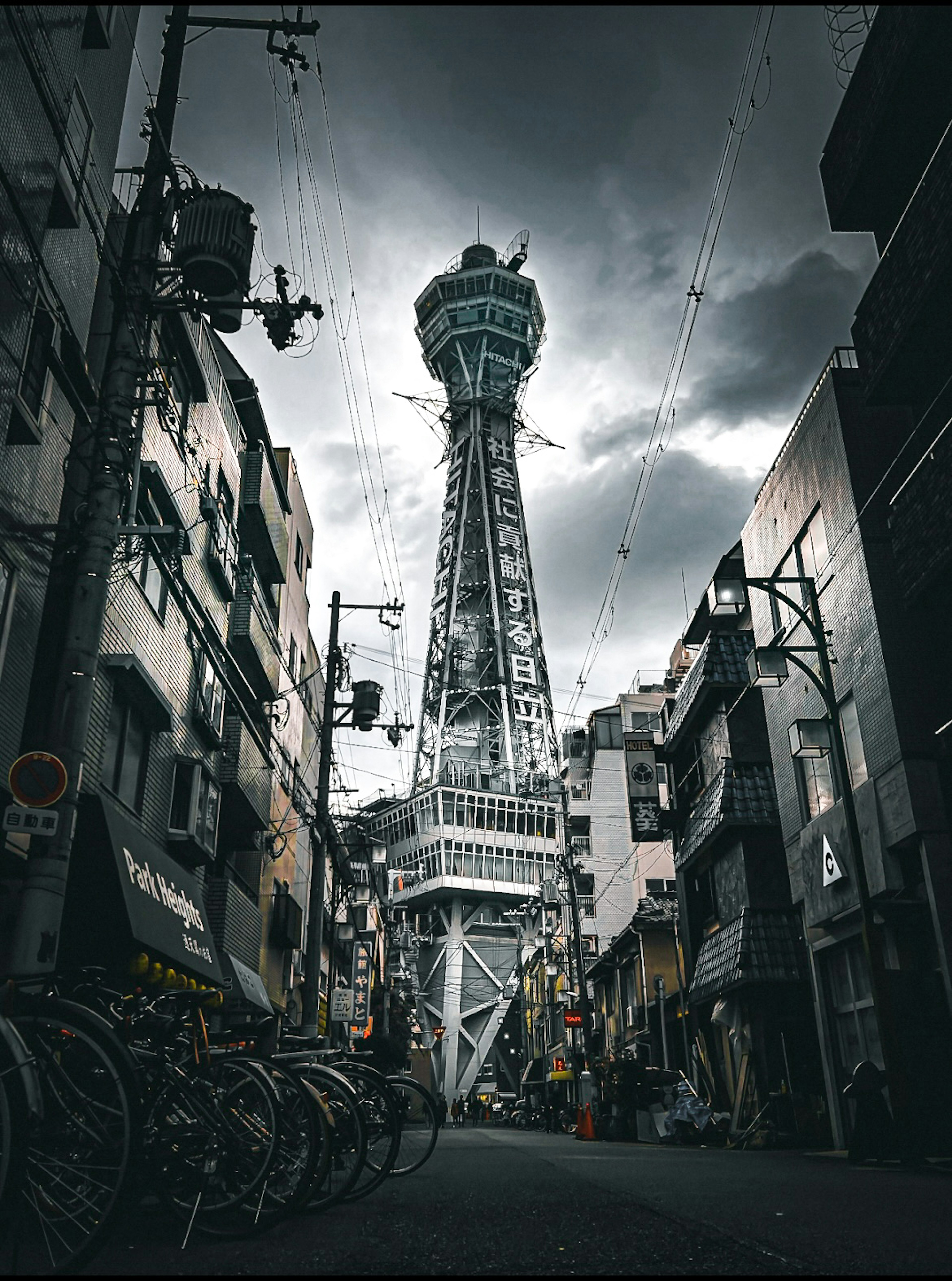 A view of Tsutenkaku Tower in Osaka surrounded by buildings