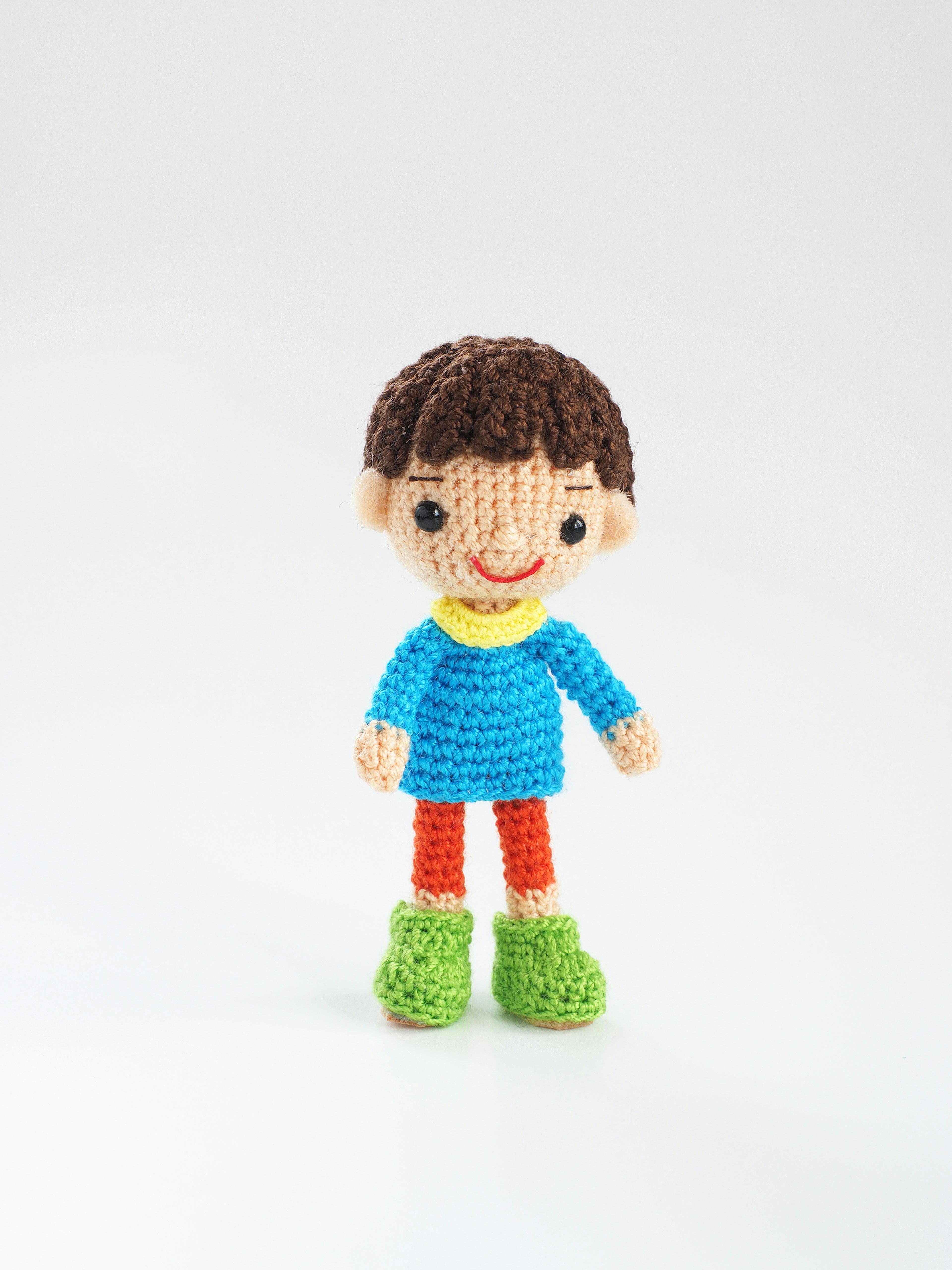 A colorful crocheted boy doll standing upright