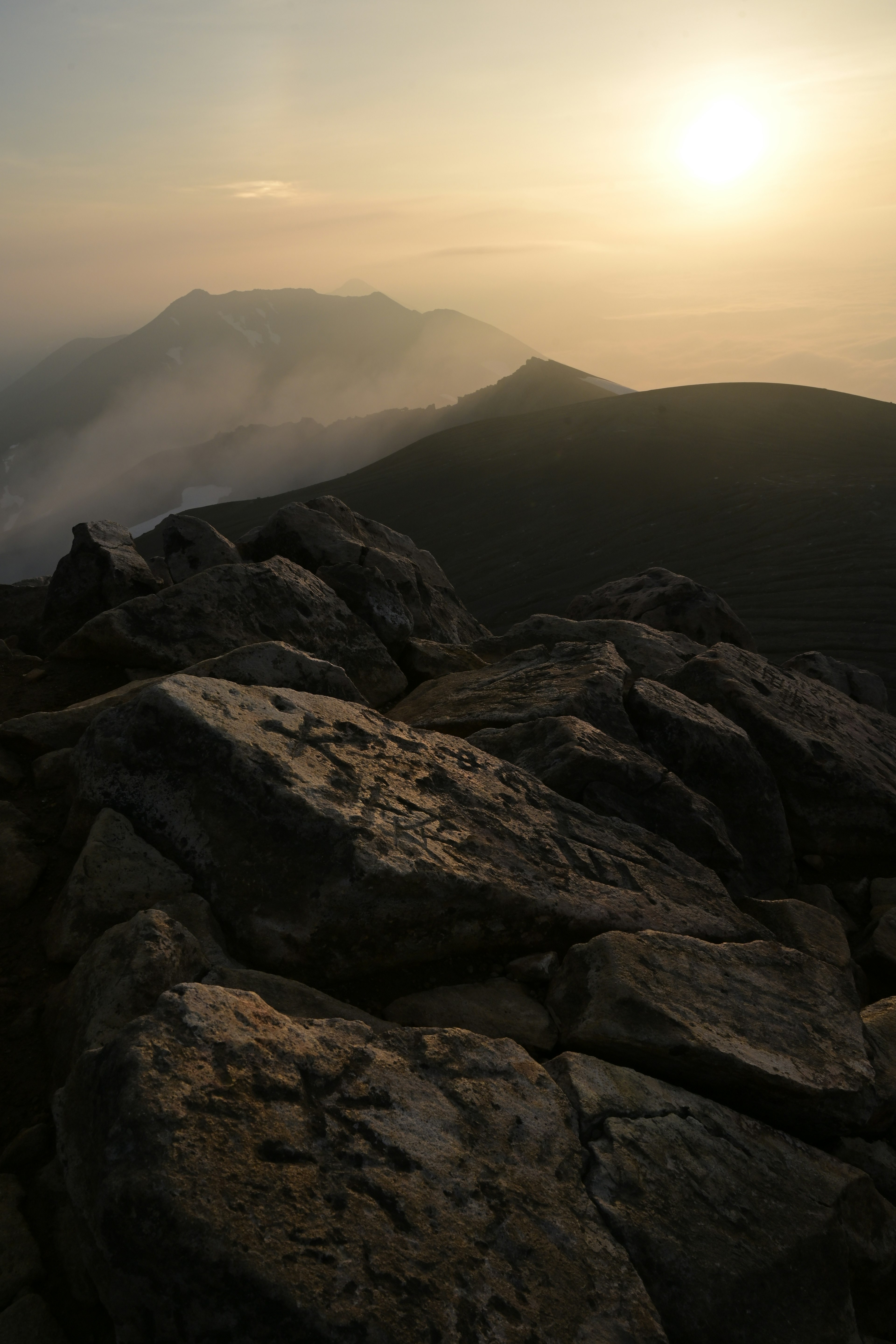 Paysage de coucher de soleil avec des montagnes et gros plan sur des rochers