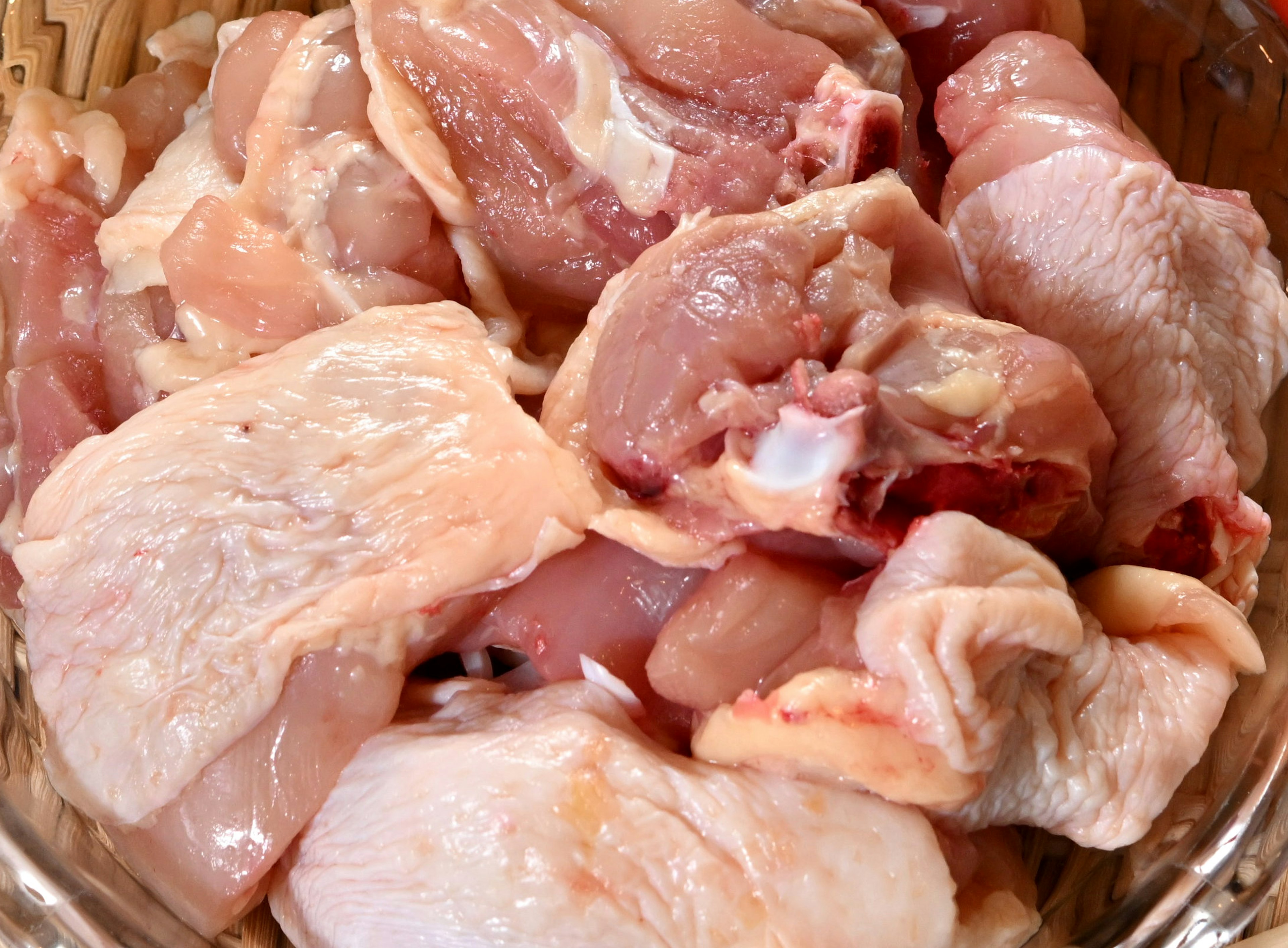 Raw chicken parts arranged in a bowl