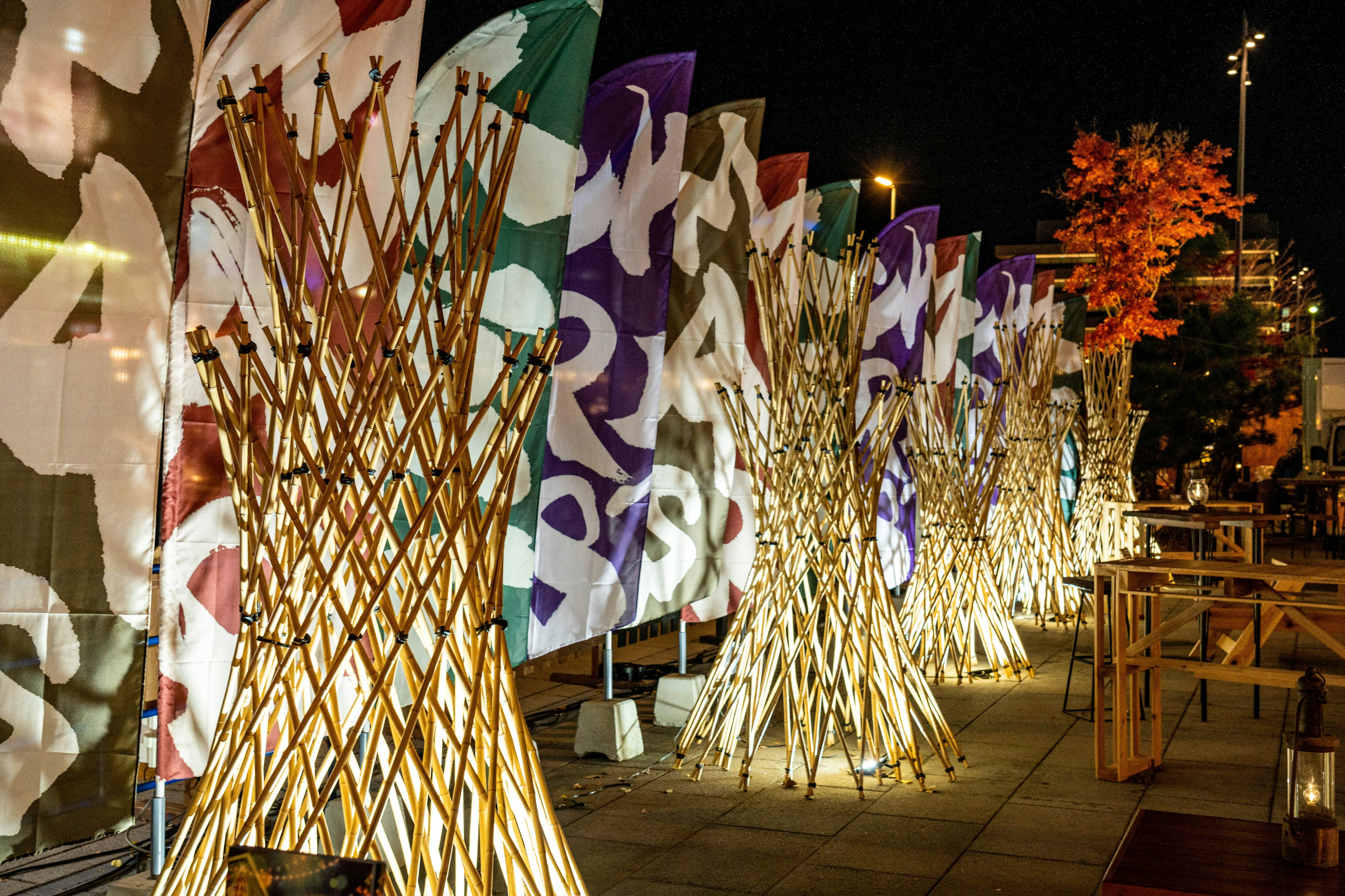 夜のイベントで色とりどりのフラッグが立ち並ぶ光景