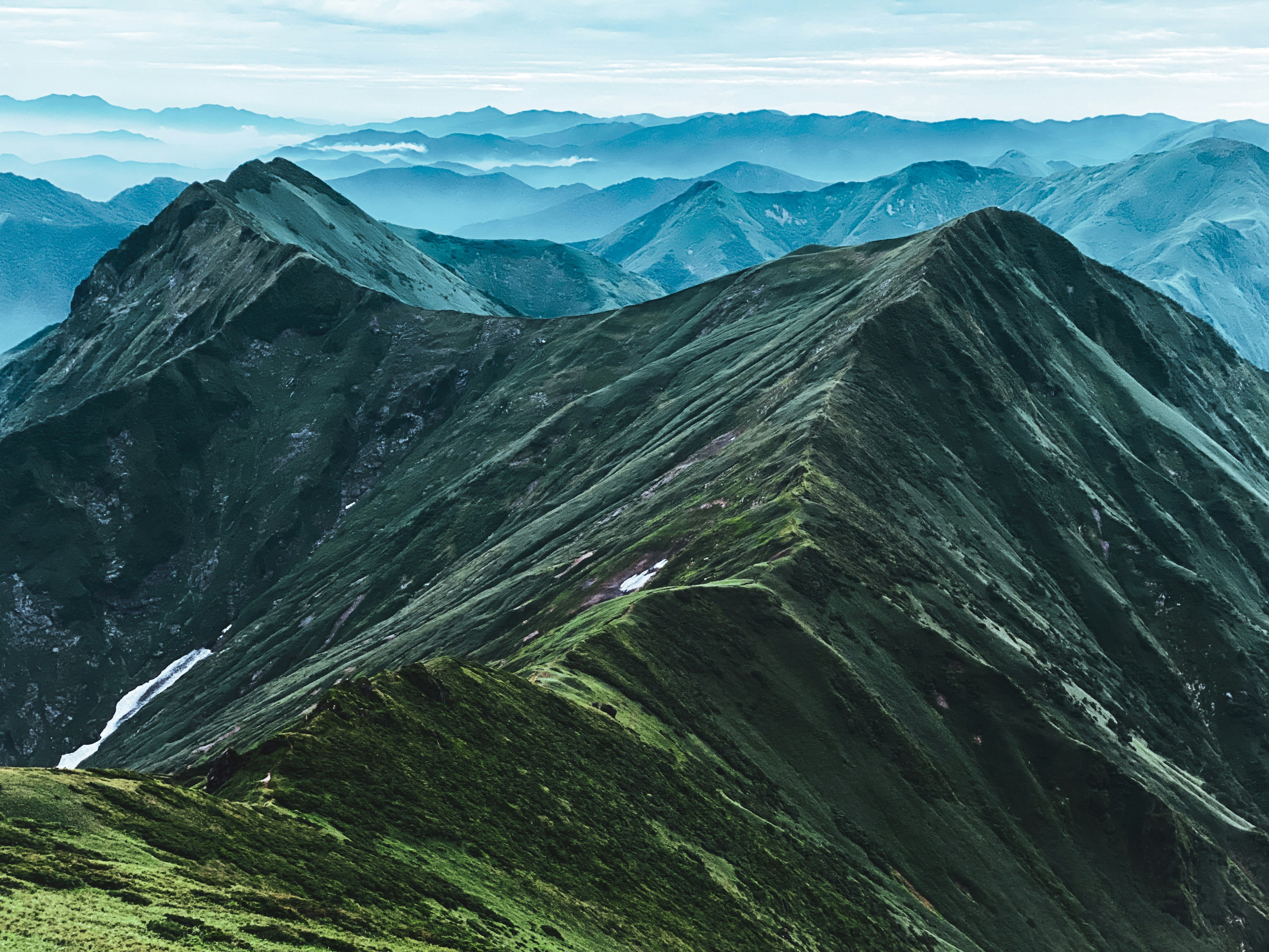 緑の山々と青い空の風景が広がる山岳地帯