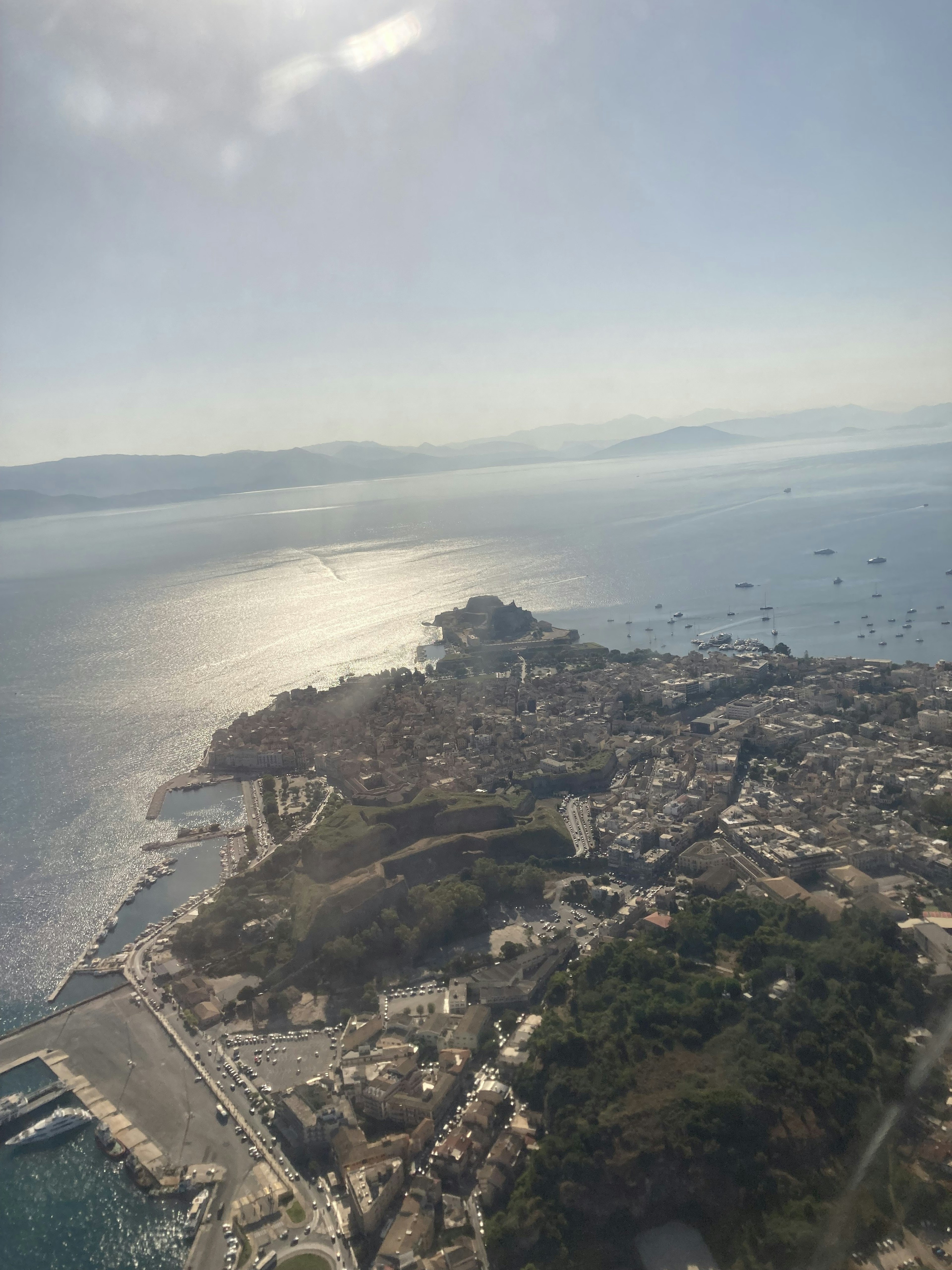 Vista aerea di una città costiera con acqua scintillante e colline