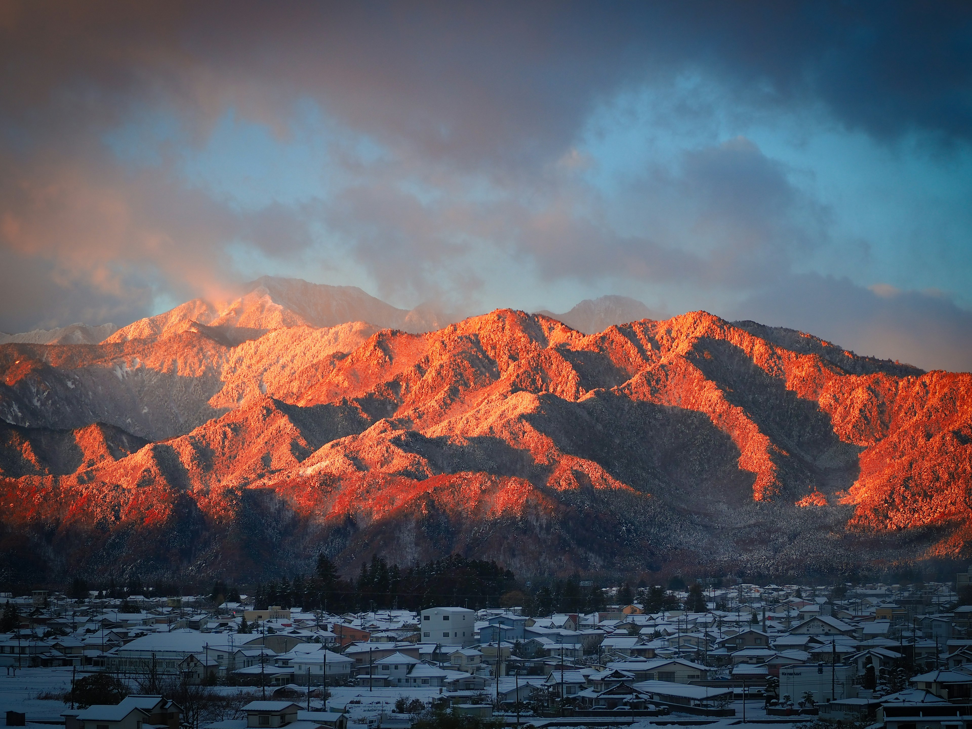 雪に覆われた山々が夕焼けに照らされている美しい風景