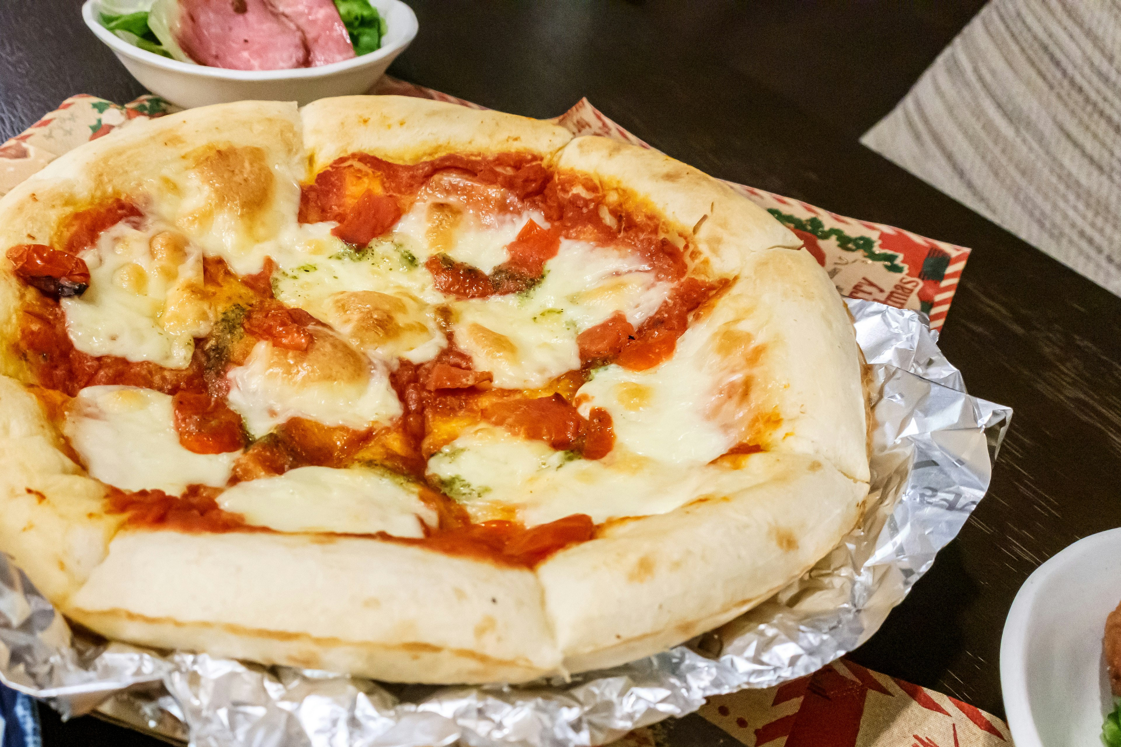 Delicious pizza topped with cheese and sauce on a silver plate