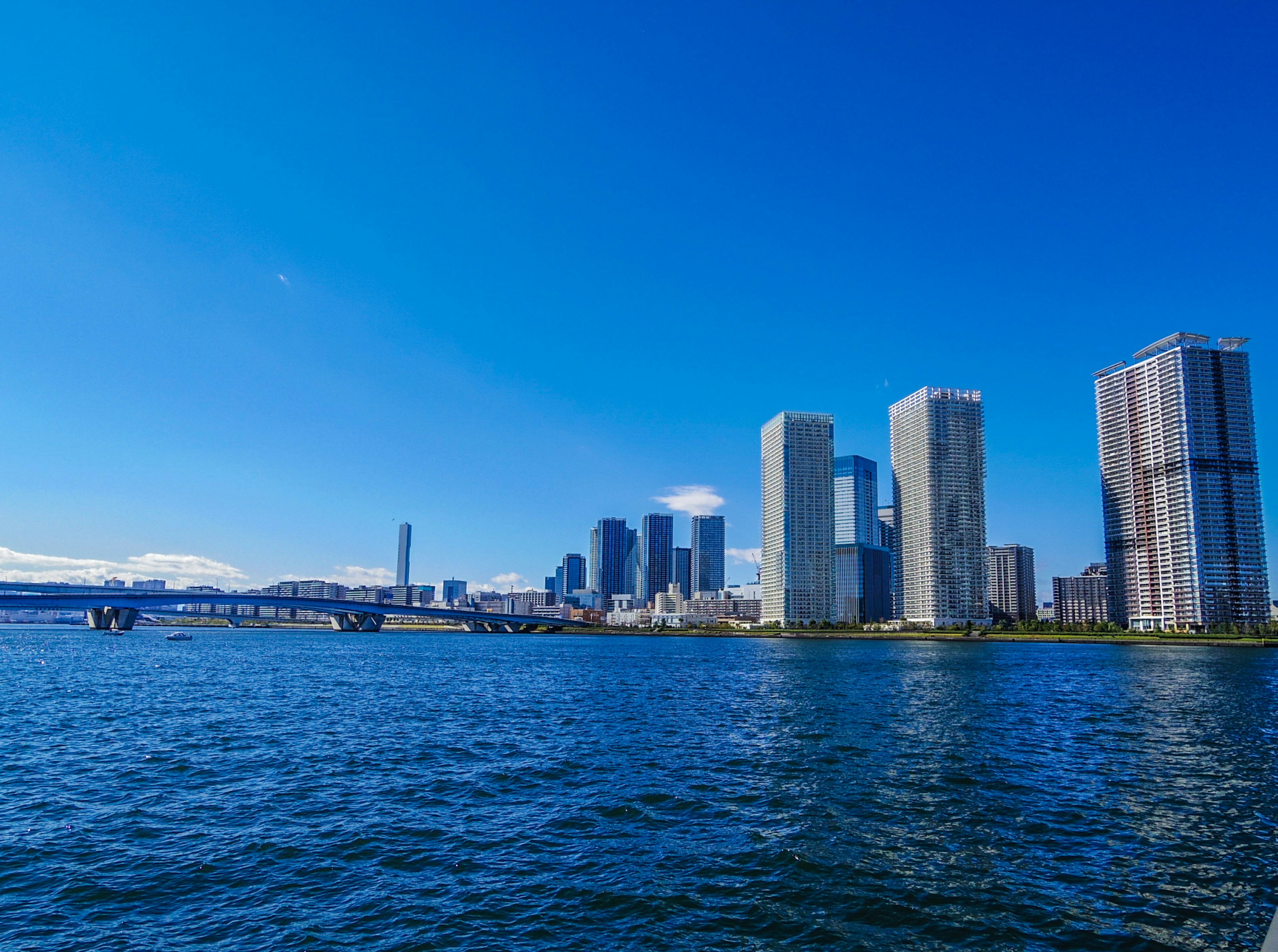 Hochhäuser entlang des Wassers unter einem klaren blauen Himmel