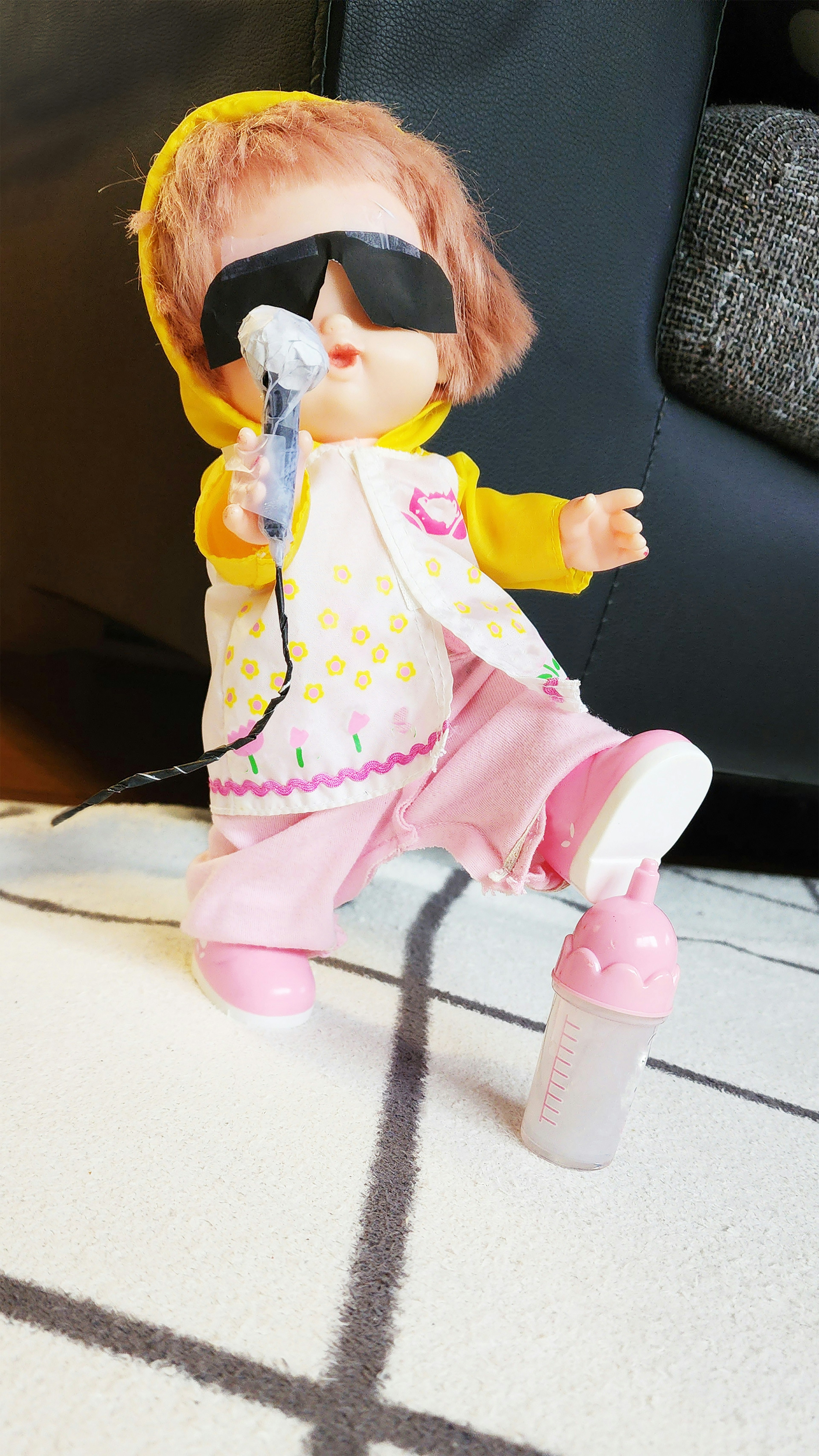 A colorful doll wearing sunglasses holding a microphone