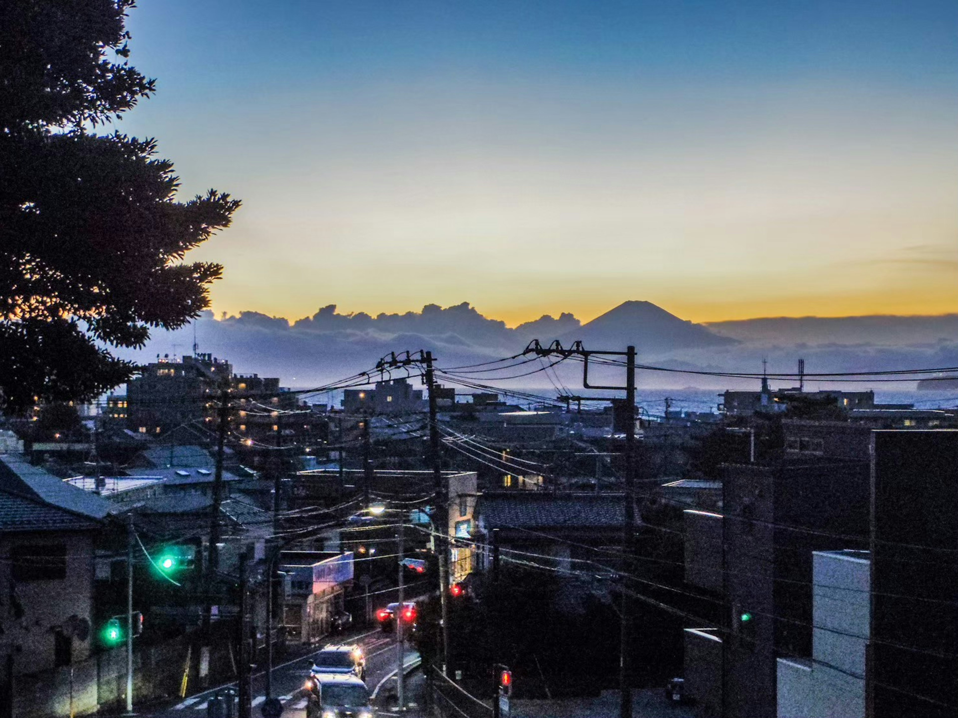 夕暮れの街並みと山々の風景が広がる