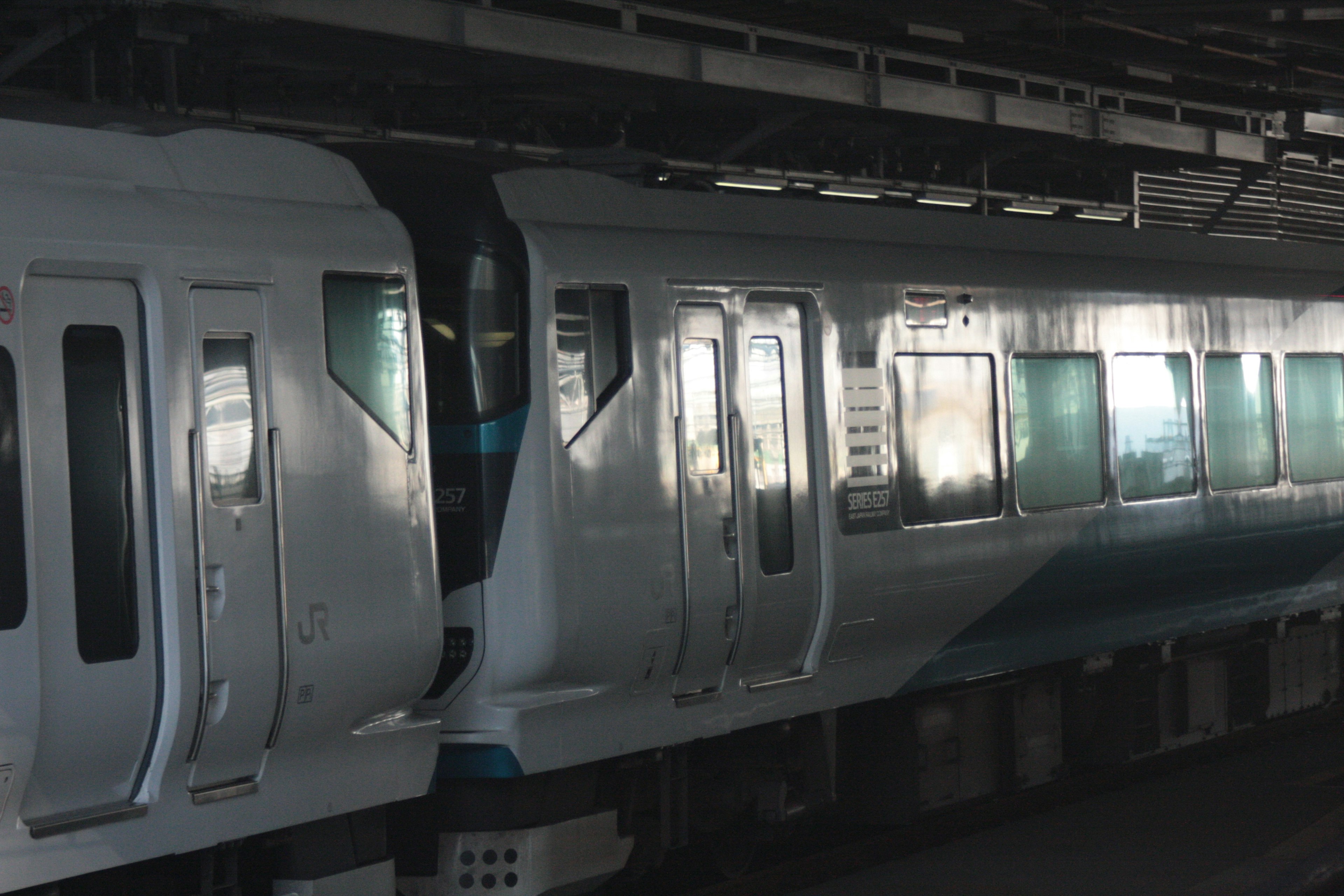 Blue and white train car at a dimly lit station