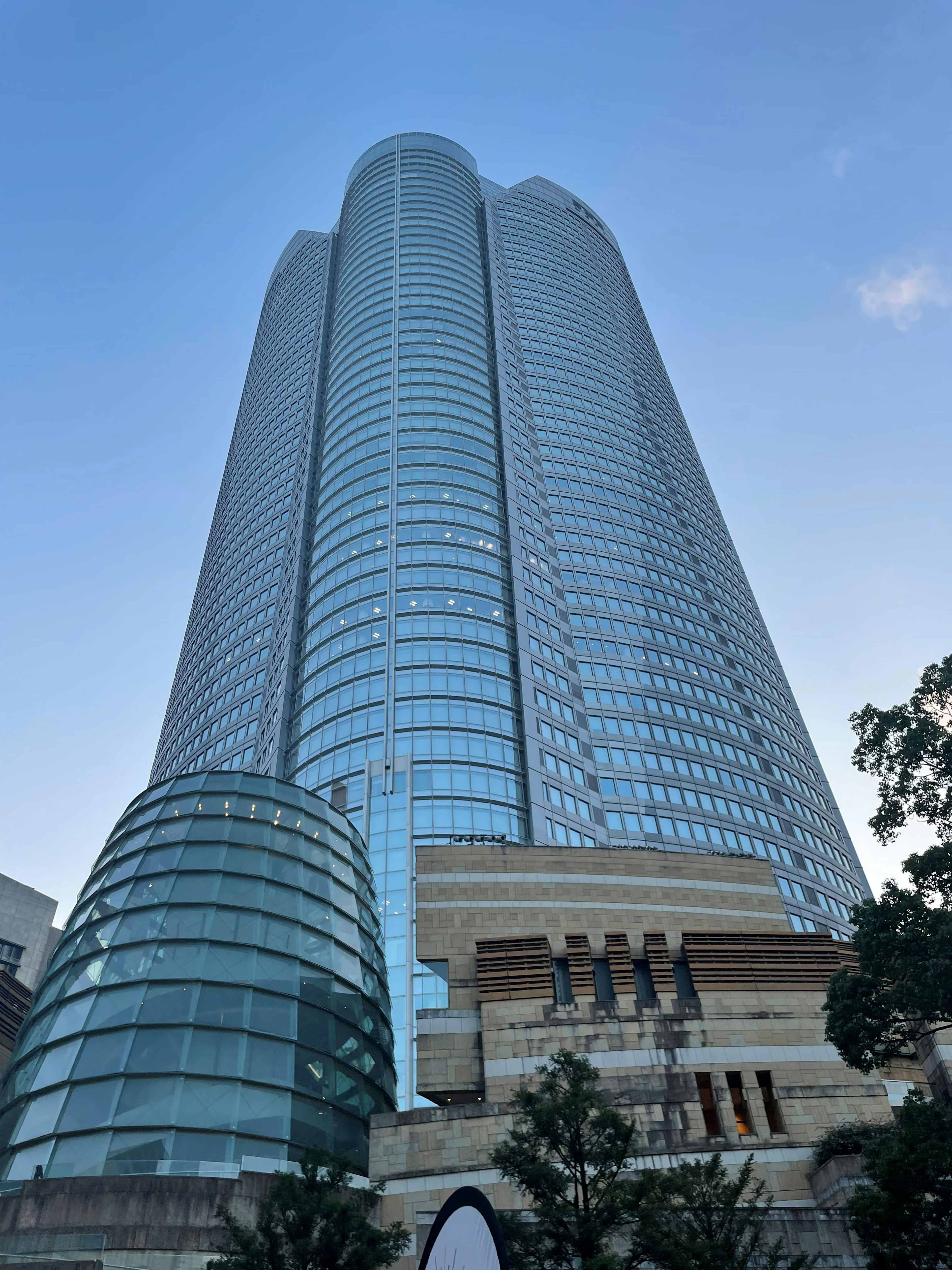 Eksterior gedung pencakar langit dengan fasad kaca di latar belakang langit biru